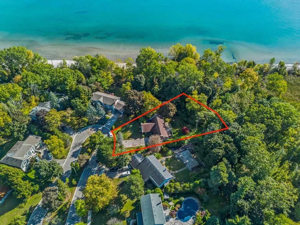 Aerial view of a property surrounded by trees near a blue lake