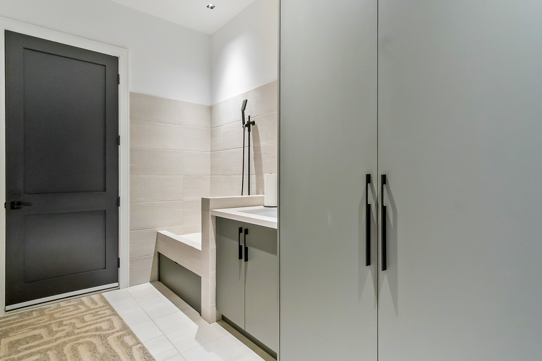 Modern bathroom with a shower, bench, and sleek cabinetry