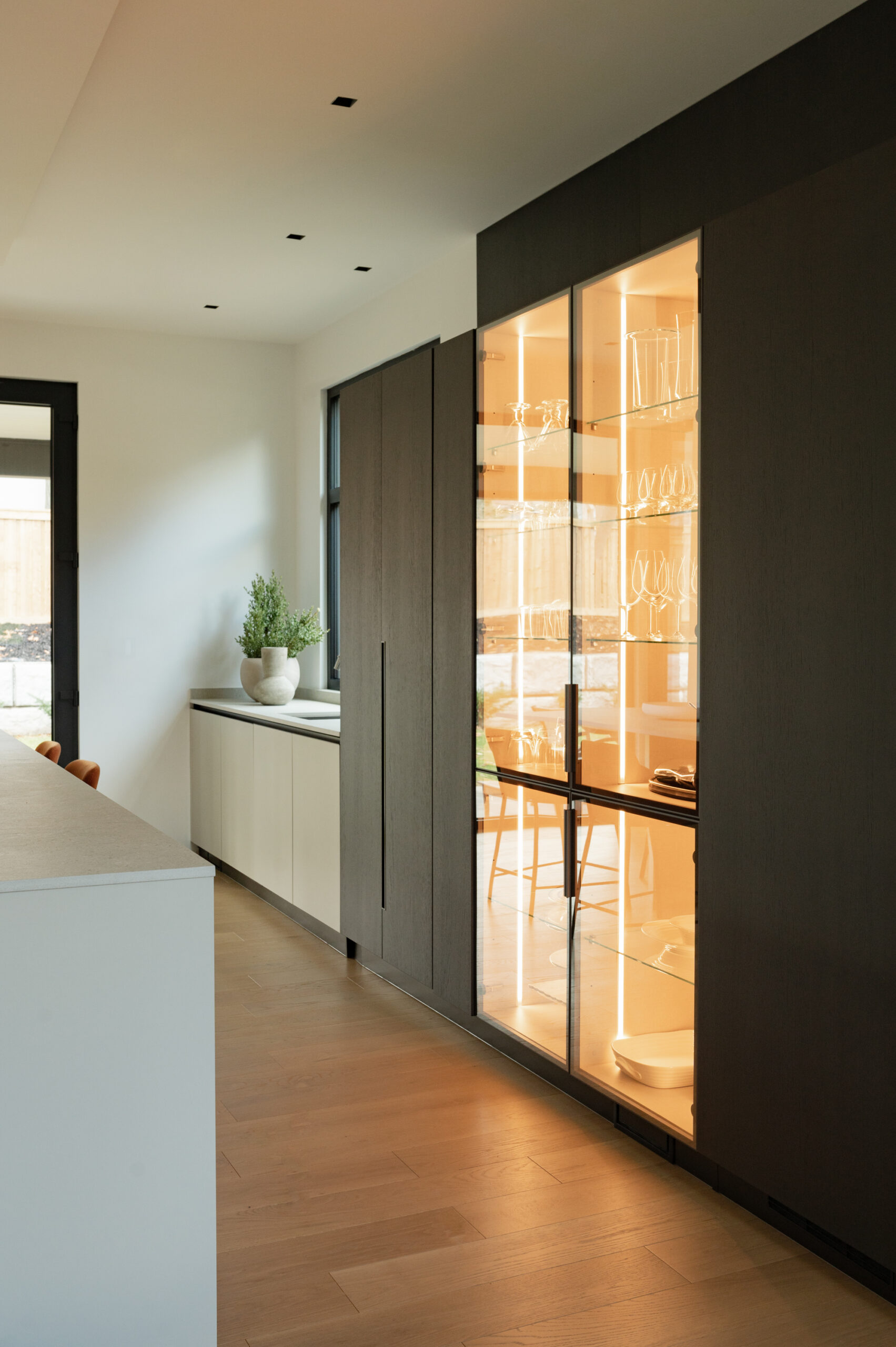 Modern kitchen with illuminated glass cabinet and wooden accents