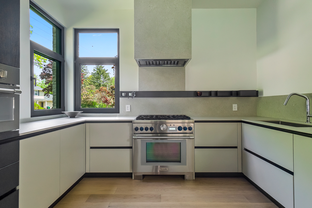 Modern kitchen with stainless steel stove and large windows