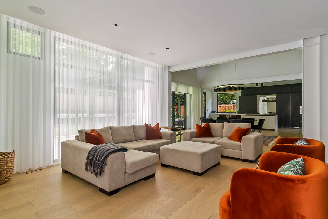 Modern living room with beige sofas and orange accent chairs