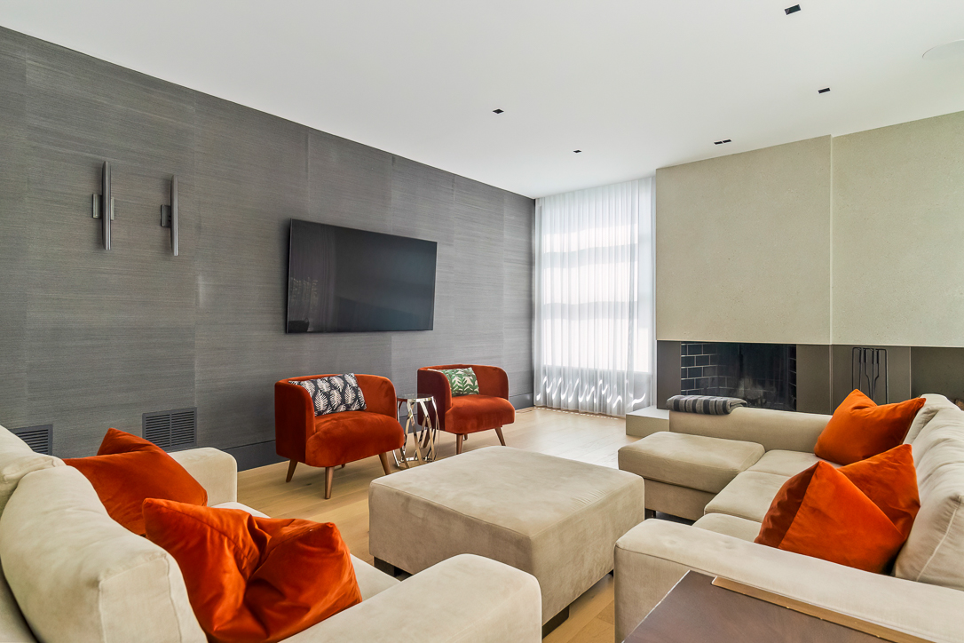 Modern living room with beige sofas and orange accent pillows