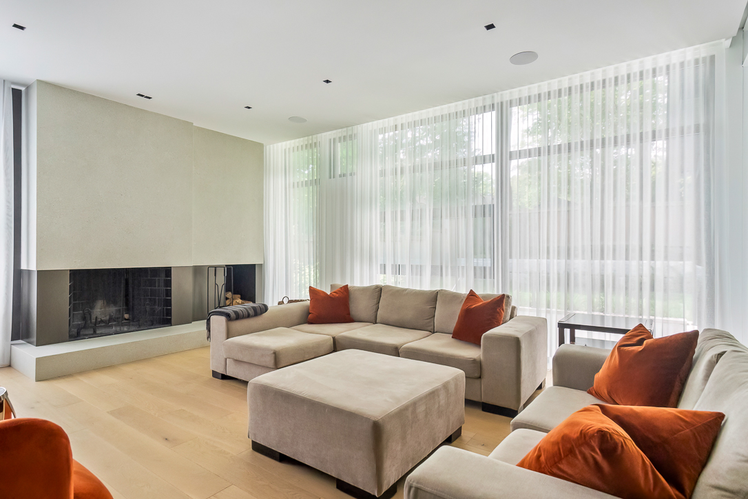 Modern living room with beige sectional sofa and orange cushions