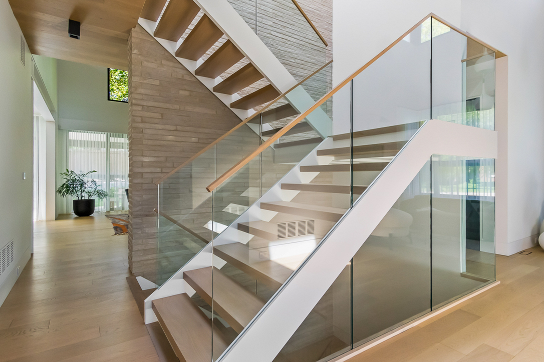 Modern staircase with glass railing and wooden steps in a bright interior