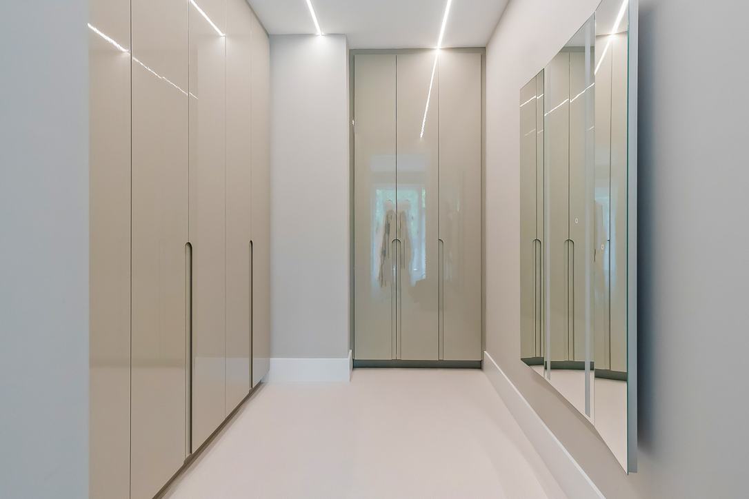 Modern hallway with sleek cabinets and large mirrors