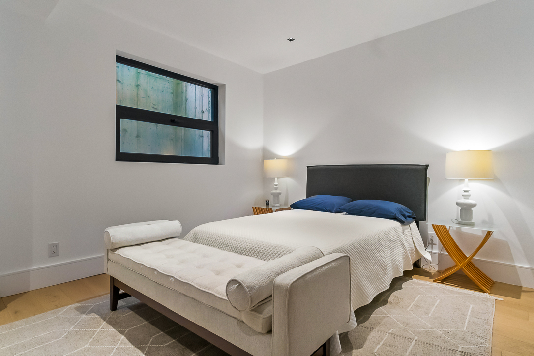 Modern bedroom with a bed, blue pillows, and stylish lamps