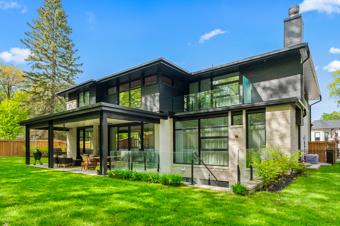Modern two-story house with large windows and green lawn