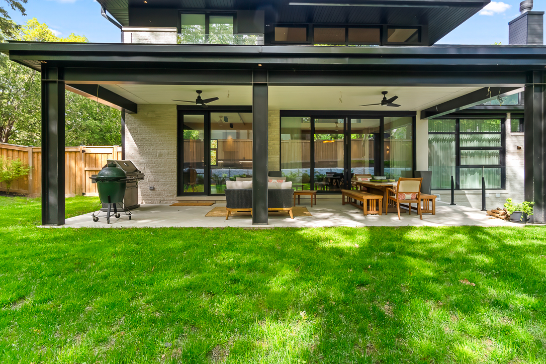 Modern patio with seating and green lawn in a residential setting