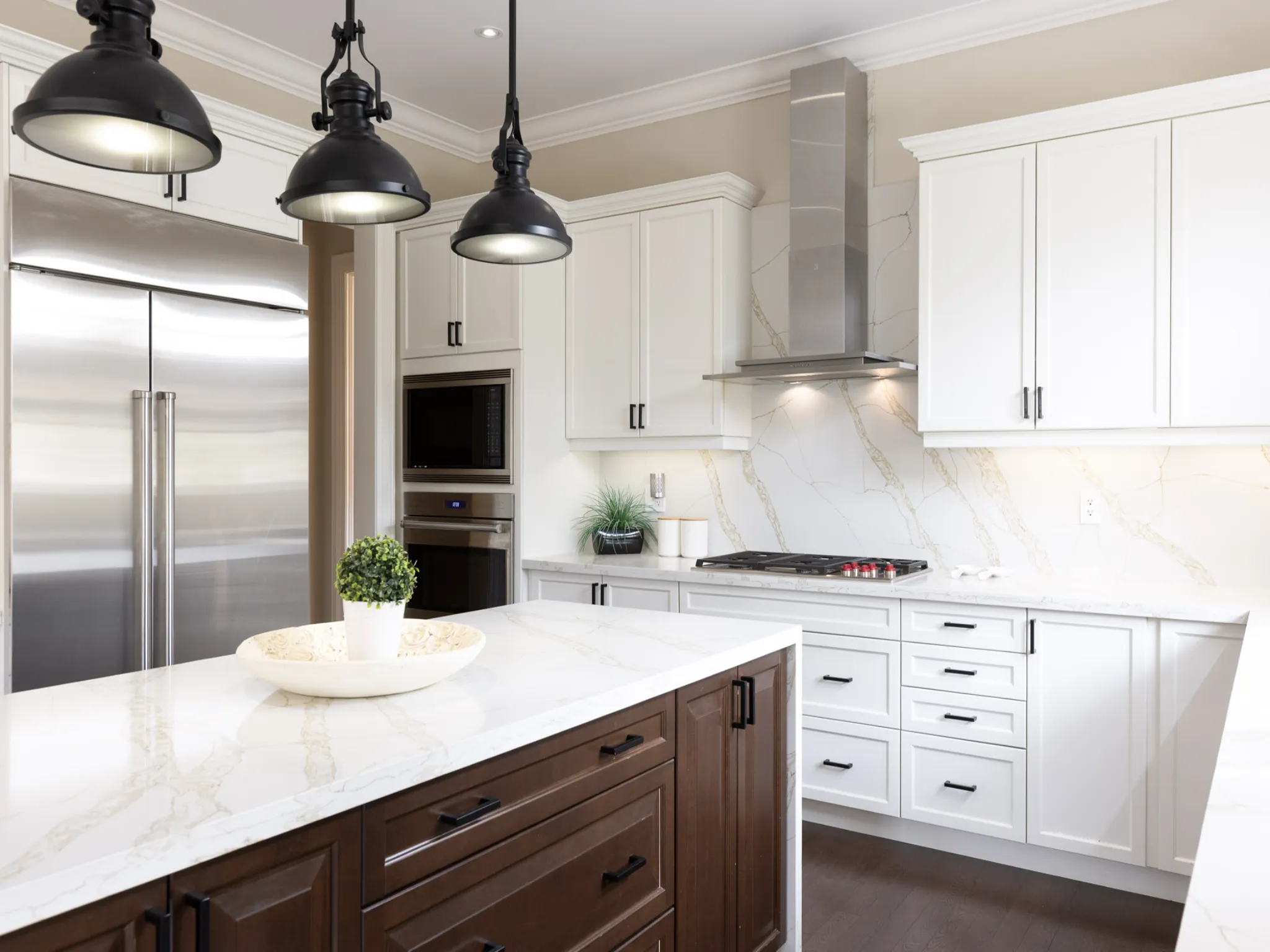 close up photograph of kitchen details - showing the pendant lights, range hood and stainless steel fridge