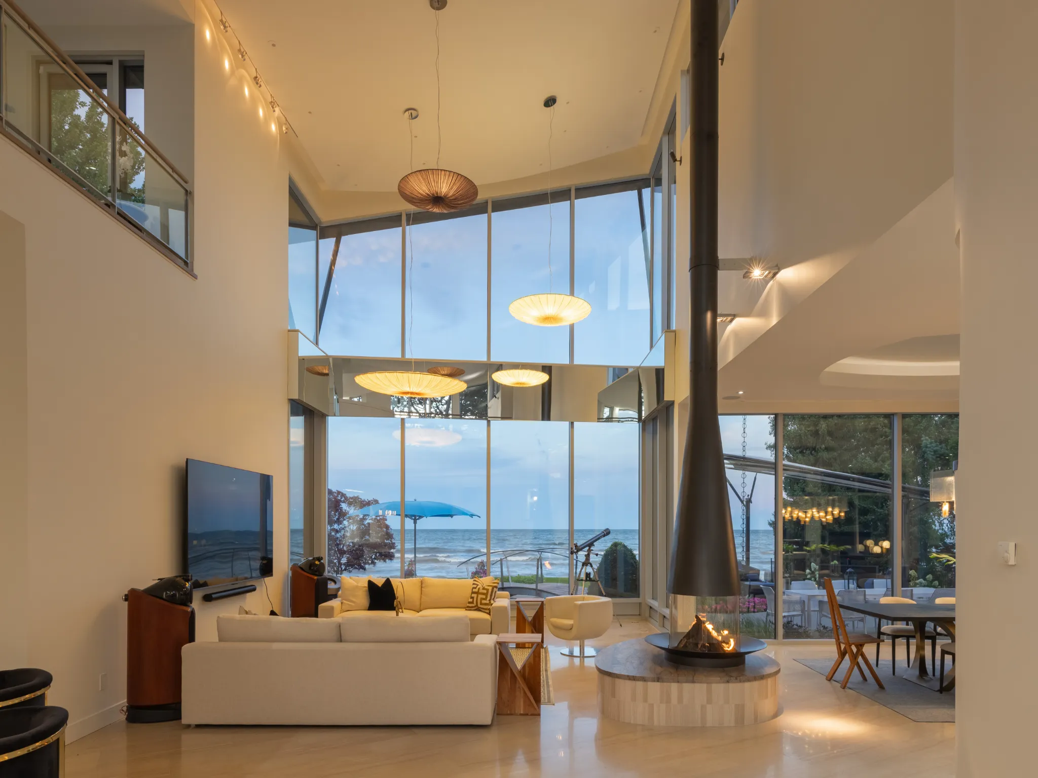 evening photo of the living room with massive windows overlooking the lake ontario