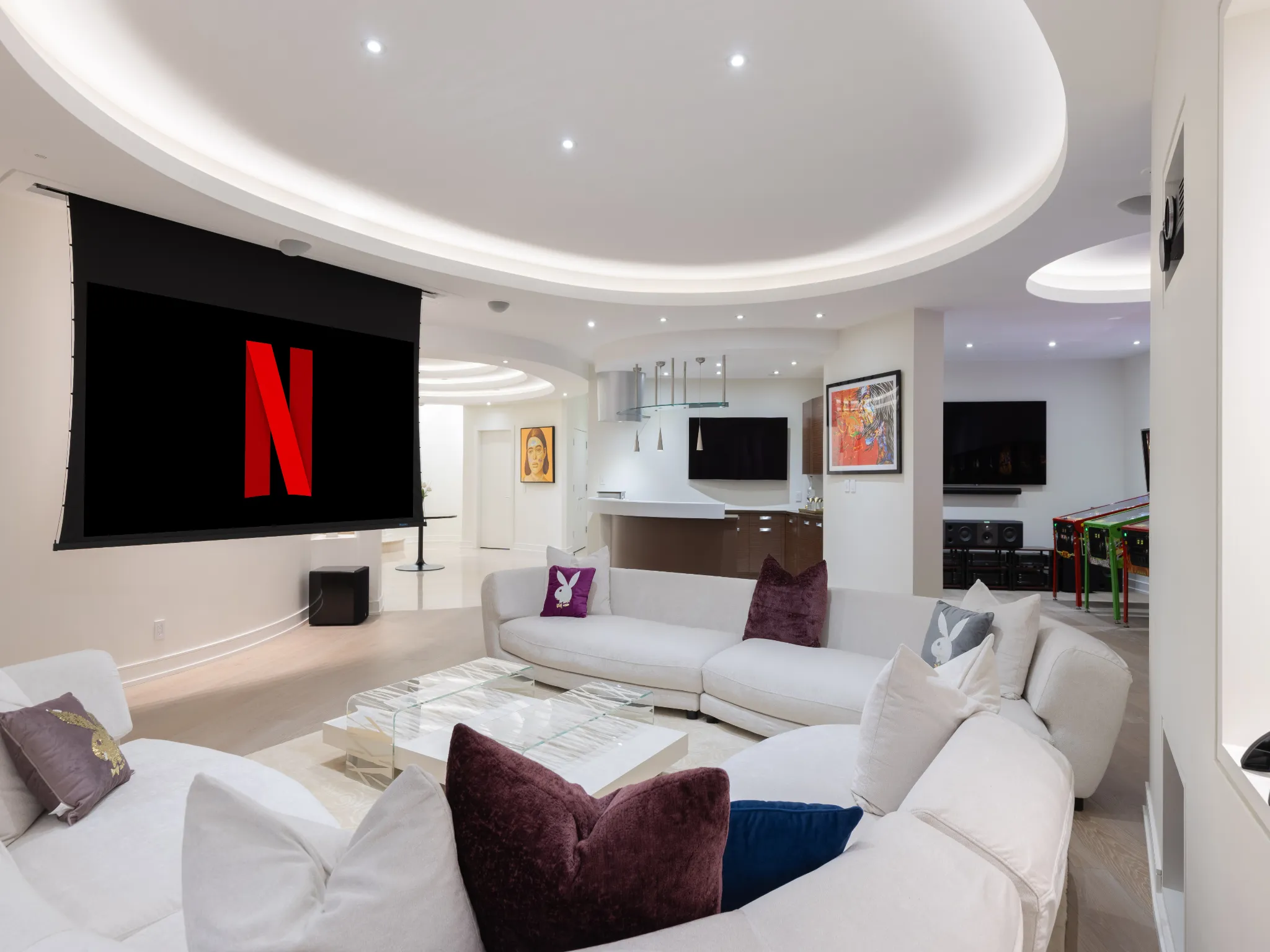 lower level theater room with large white leather couches and huge entertainment space