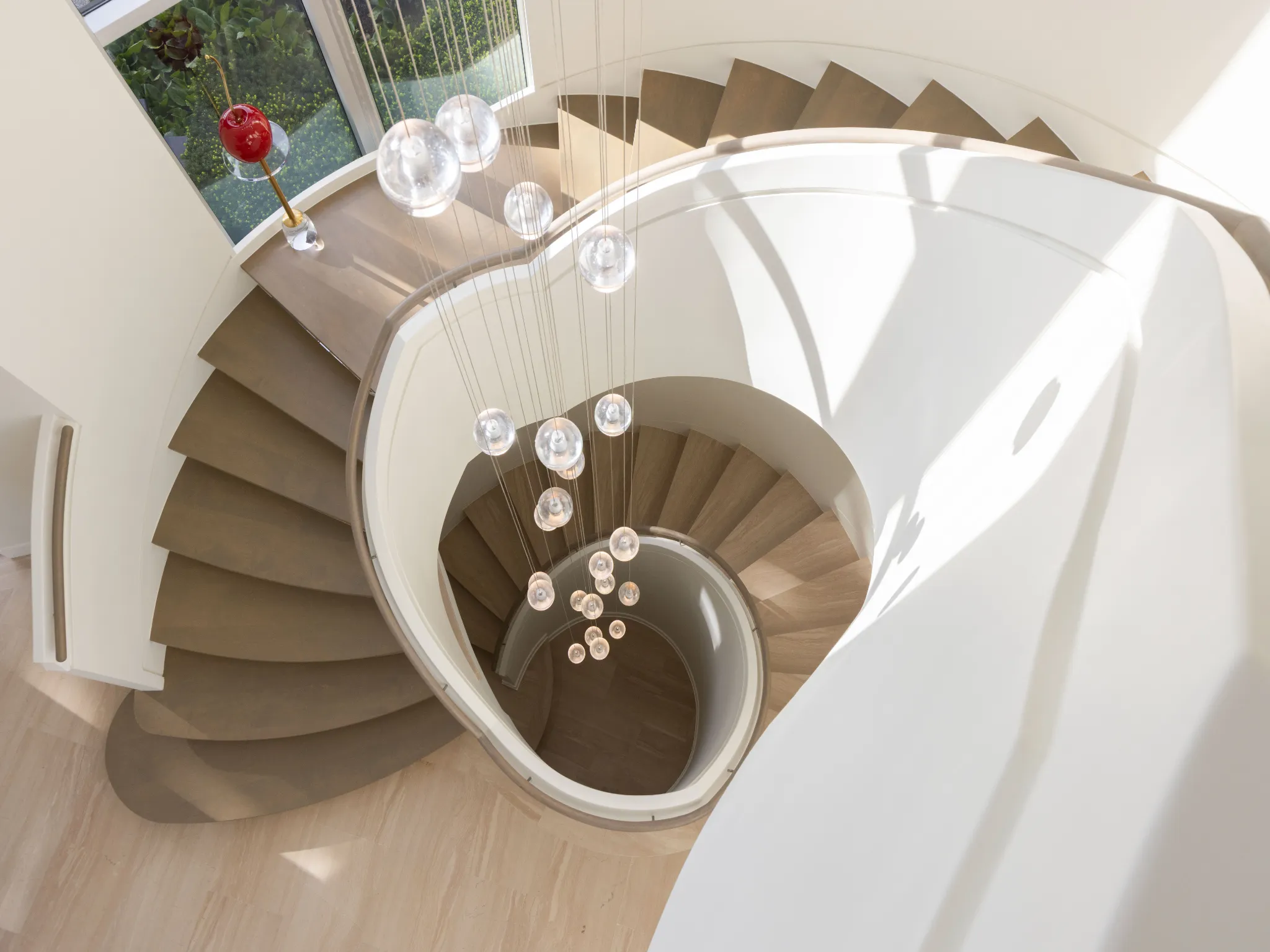 modern staircase with large crystal chandelier that spans many levels