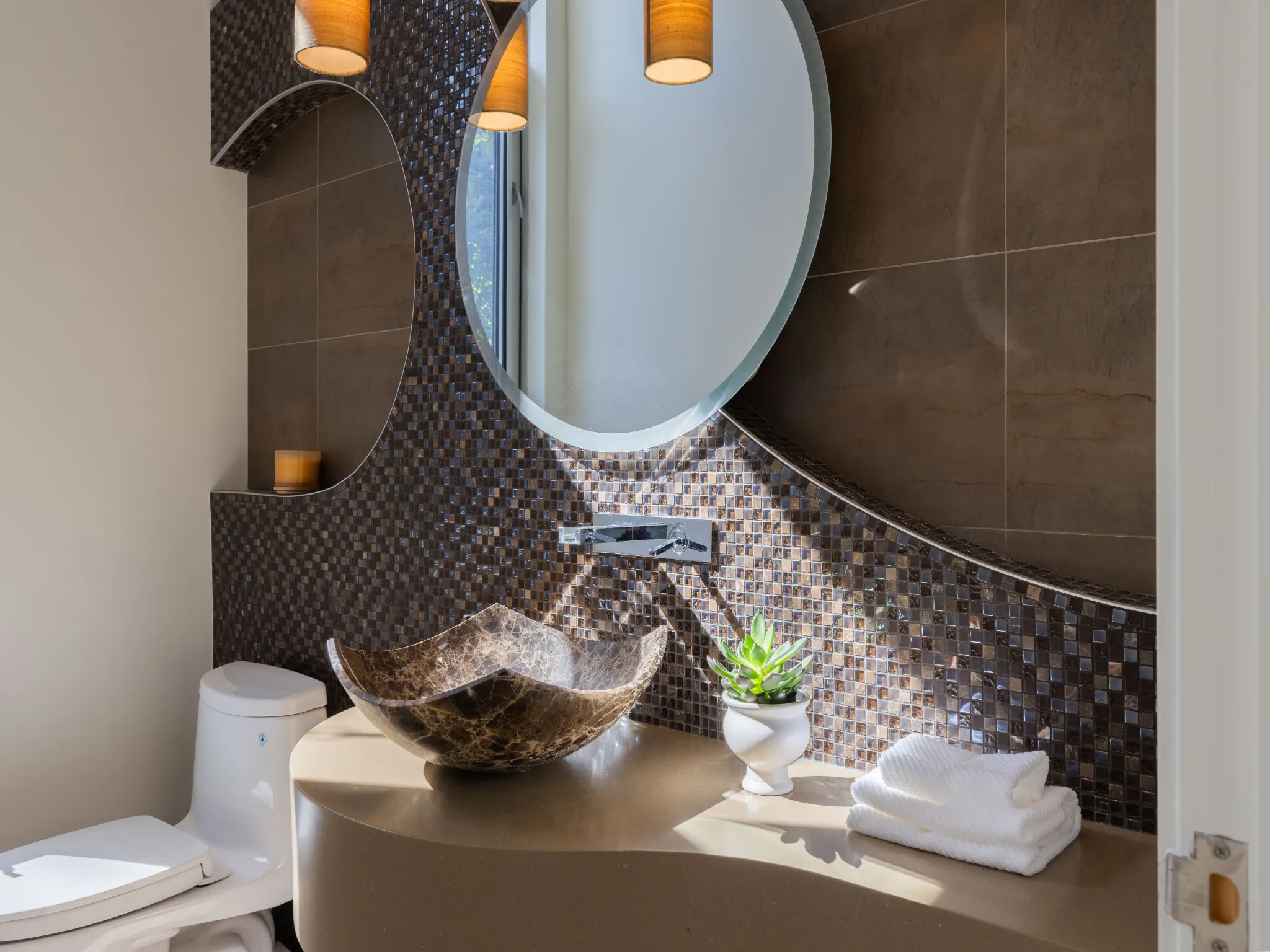 powder room with mosaic tiles and circle mirror