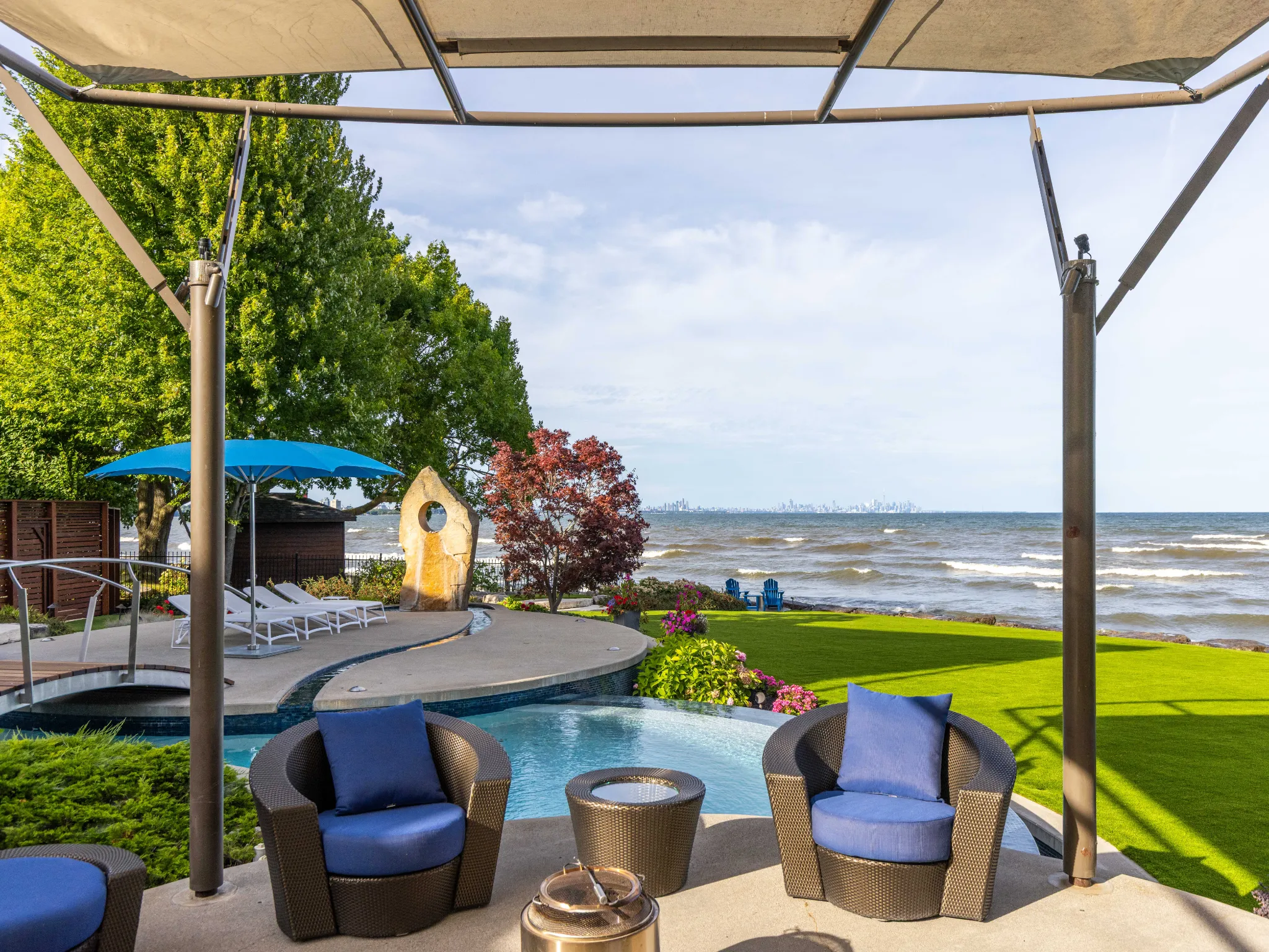 backyard seating area with blue chairs and lake in the background