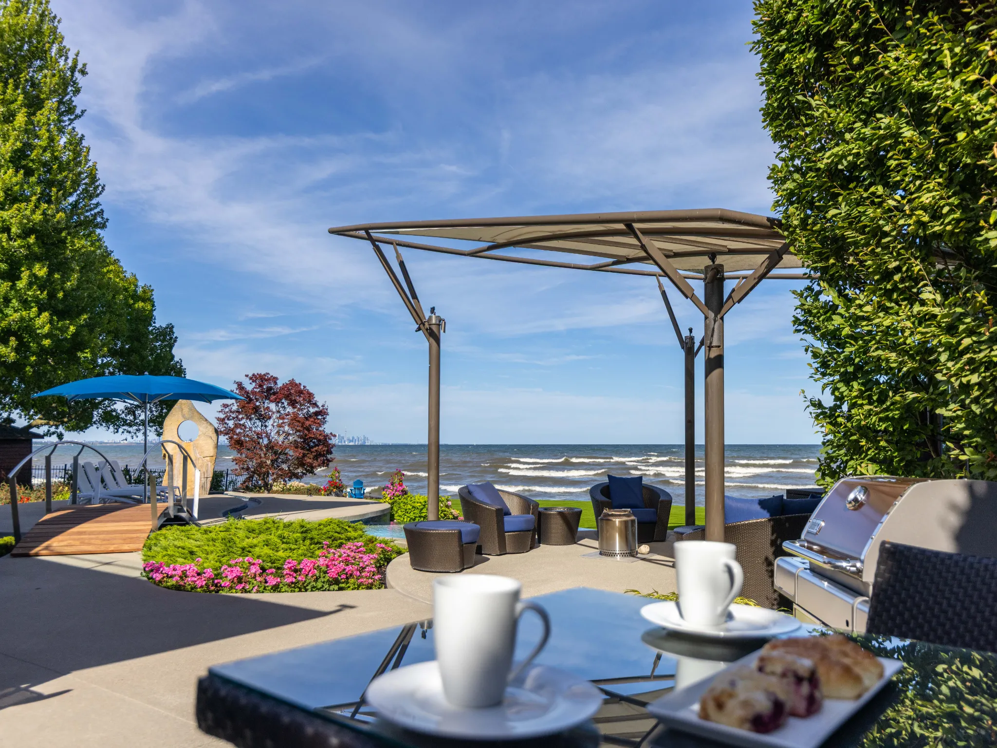 backyard photo of the yard and lake with two coffee cups