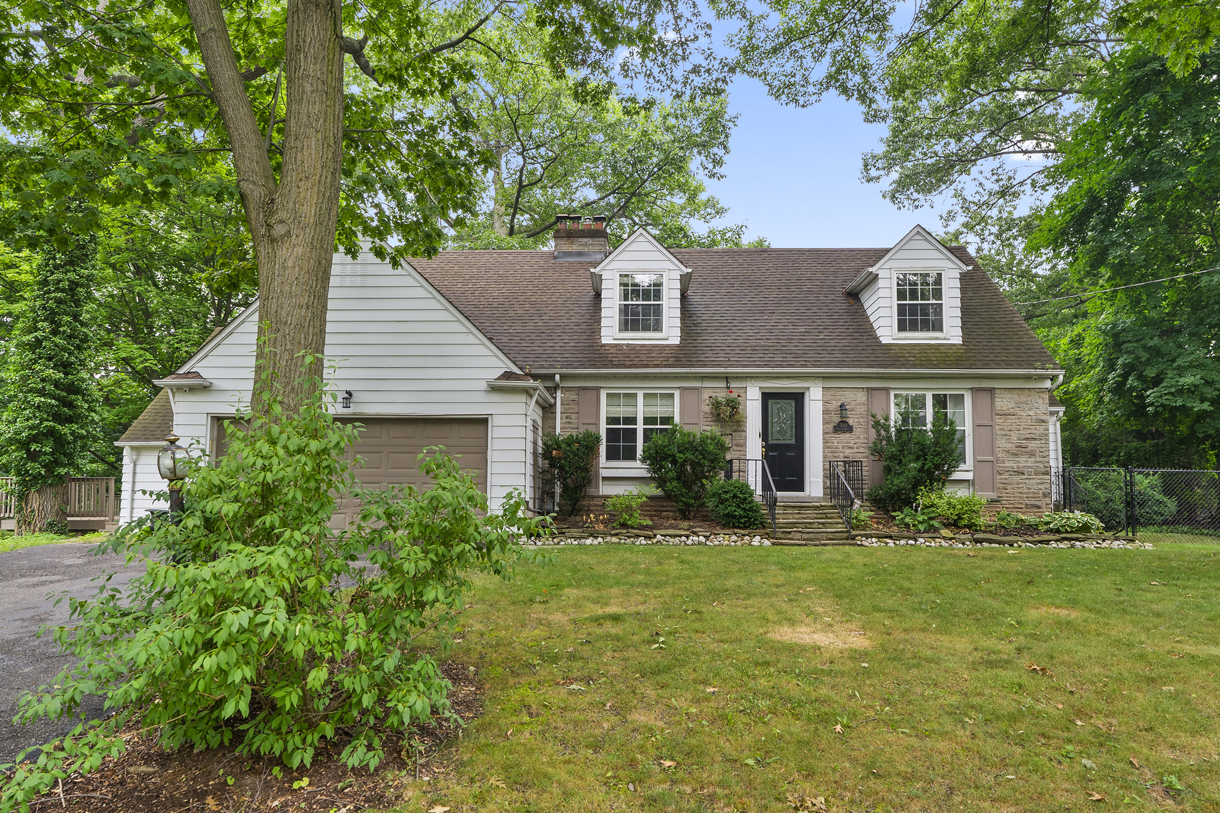 Charming house with a stone facade and landscaped yard