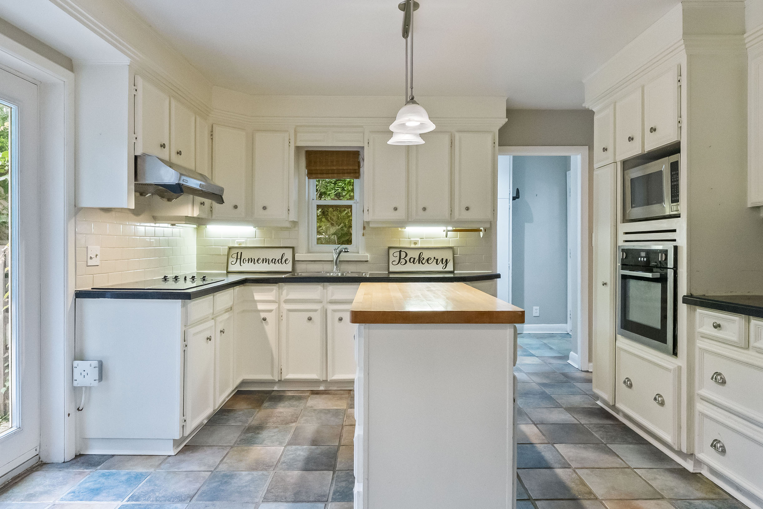Bright kitchen with white cabinets, island, and modern appliances