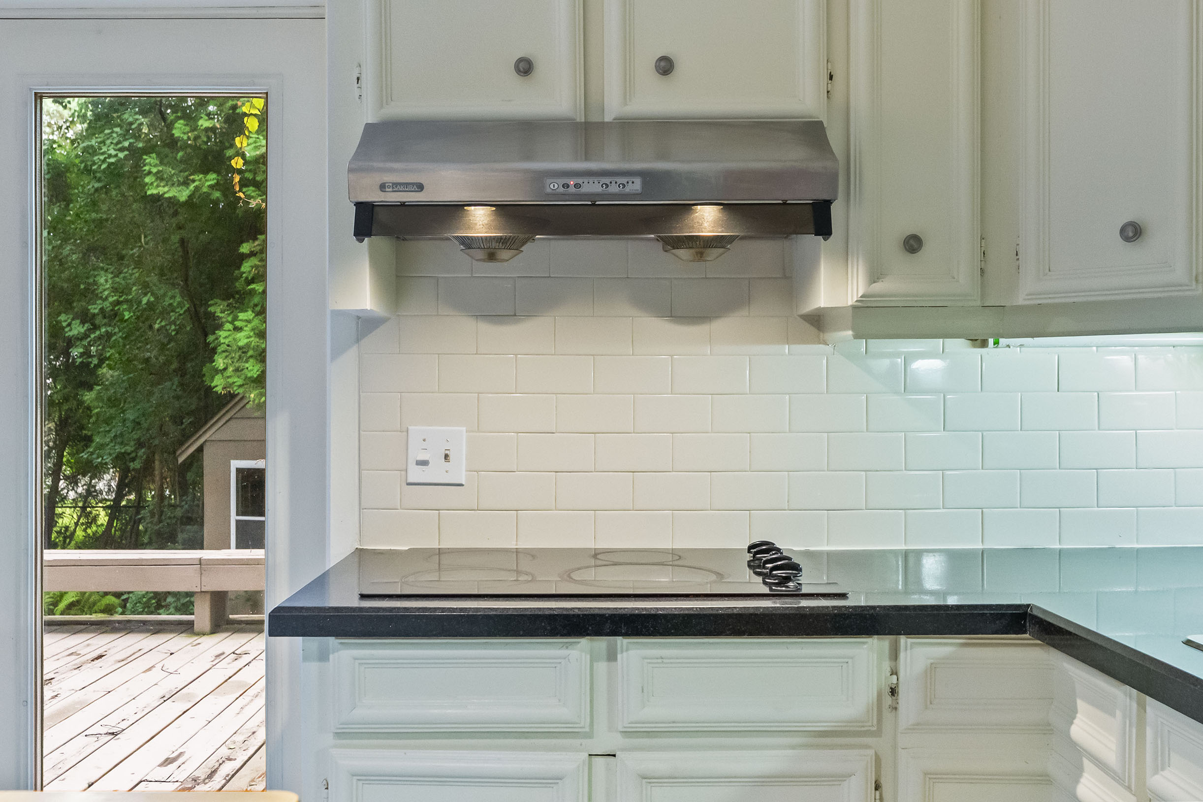 Modern kitchen with stainless steel range hood and black countertop
