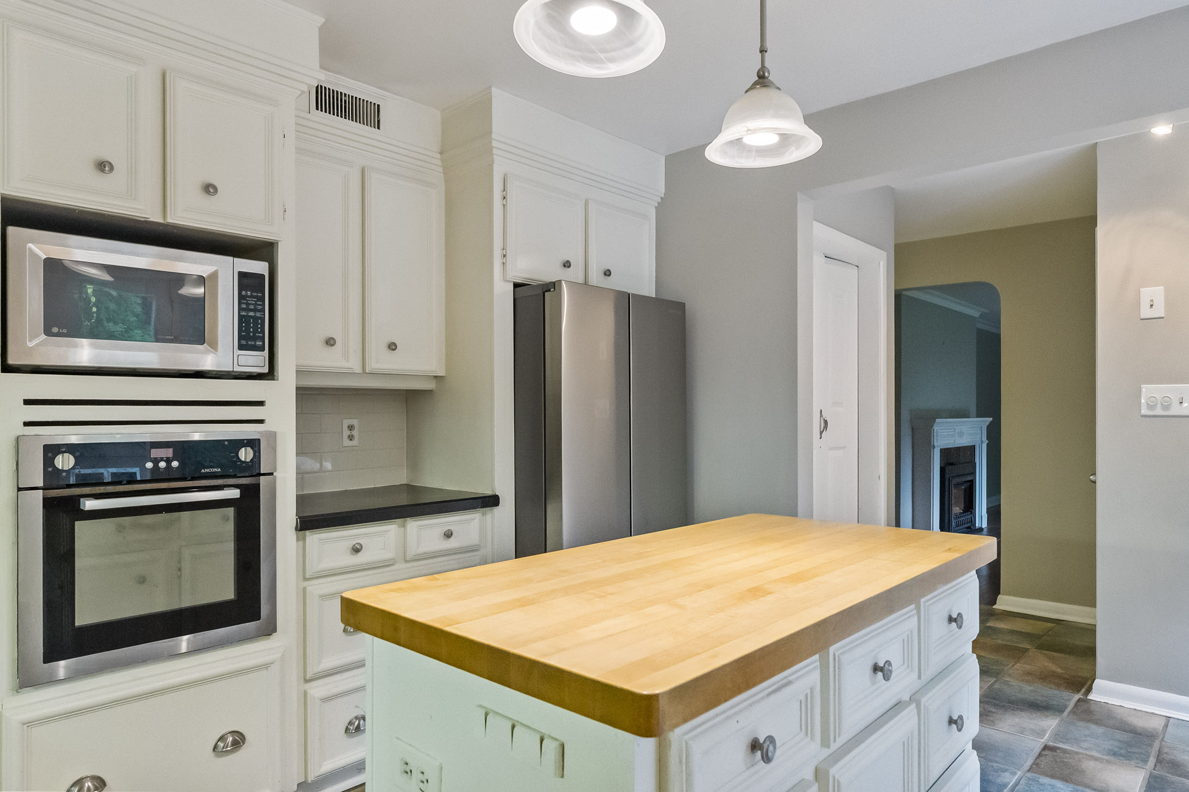 Modern kitchen with white cabinets and wooden island countertop