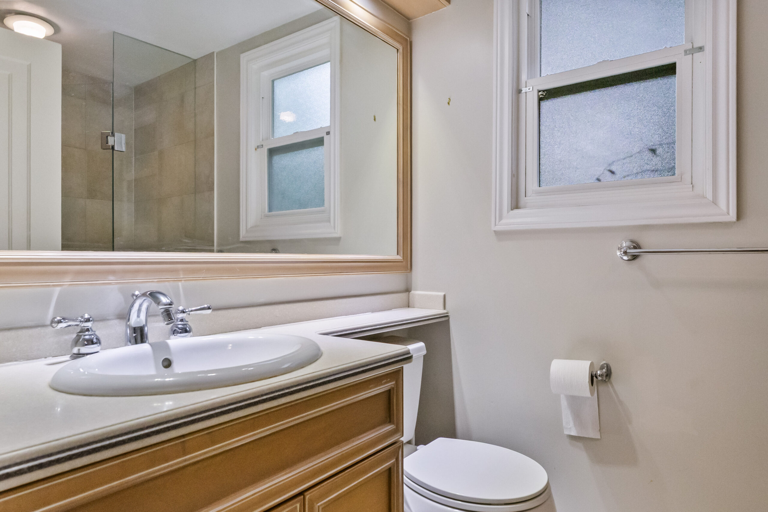 Modern bathroom with a sink, toilet, and natural light from a window