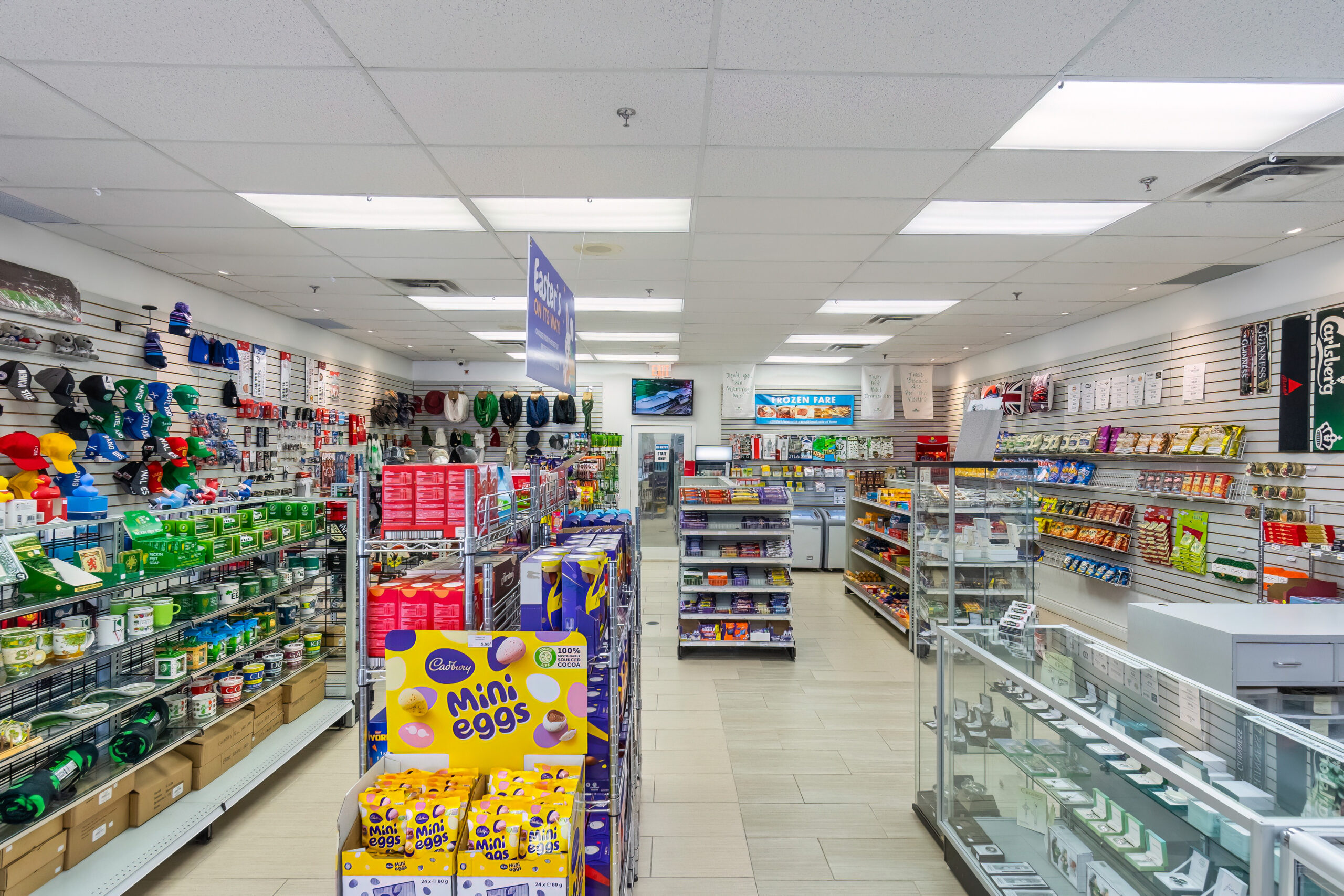 Brightly lit convenience store aisle filled with various products and shelves