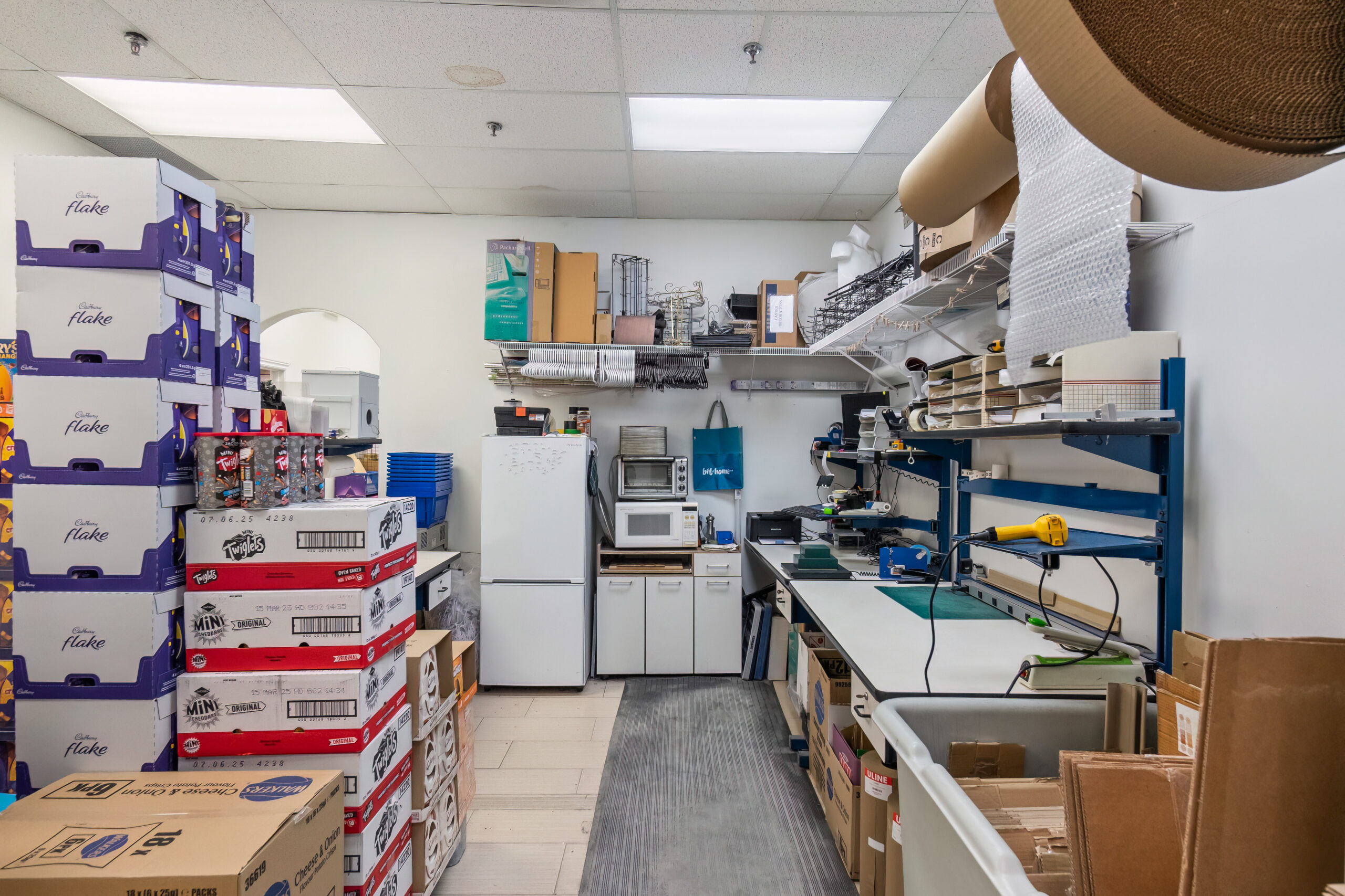 Storage room filled with boxes, shelves, and a workbench setup