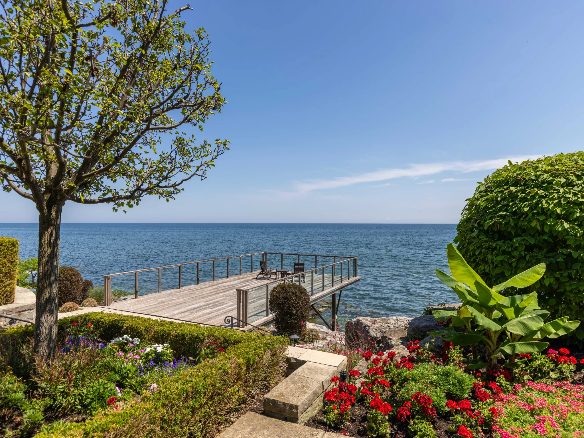 exterior deck overlooking lake ontario. professionally landscaped backyard