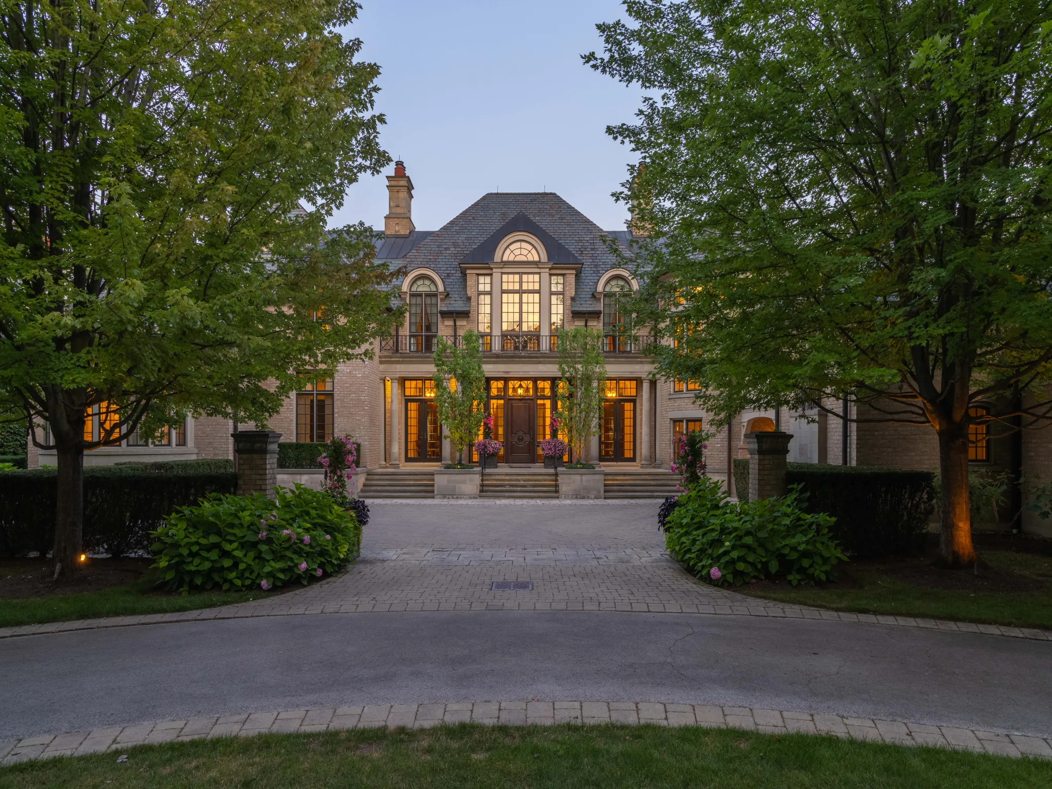 exterior of the home during the evening with lights warming glowing from within