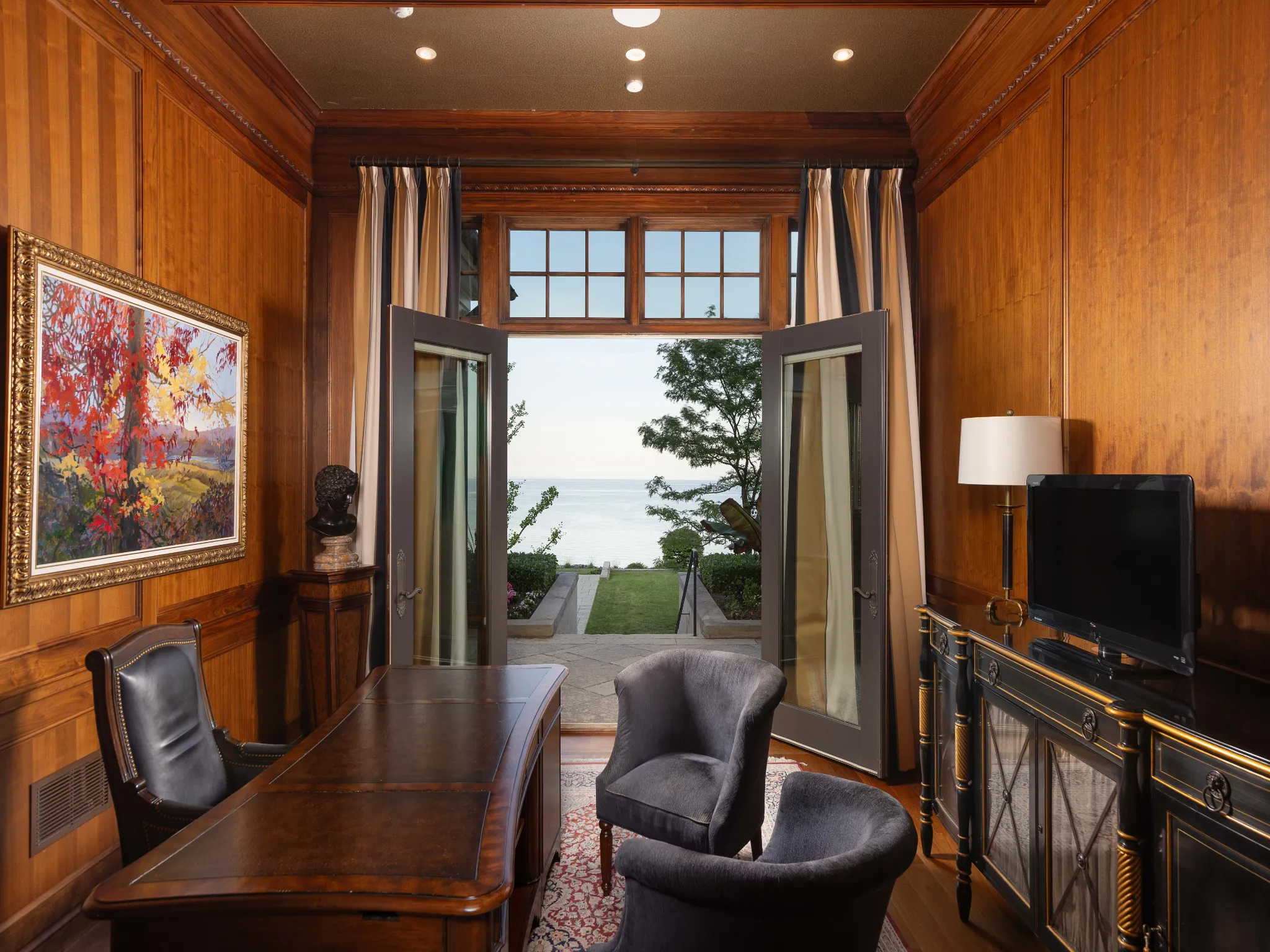 luxurious home office with wood panelled walls and views of lake ontario