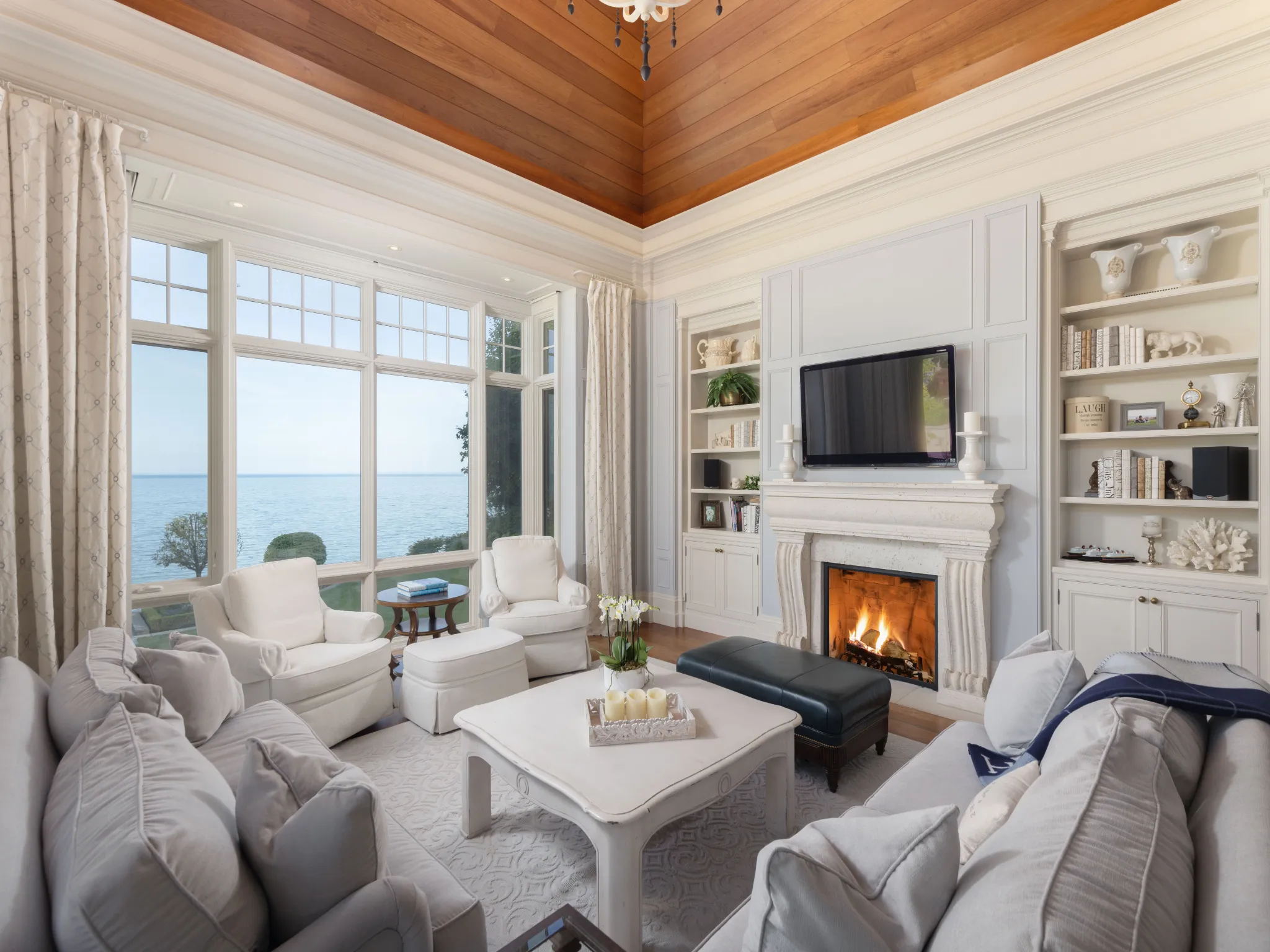 living room overlooking the lake with a fireplace and vaulted ceilings