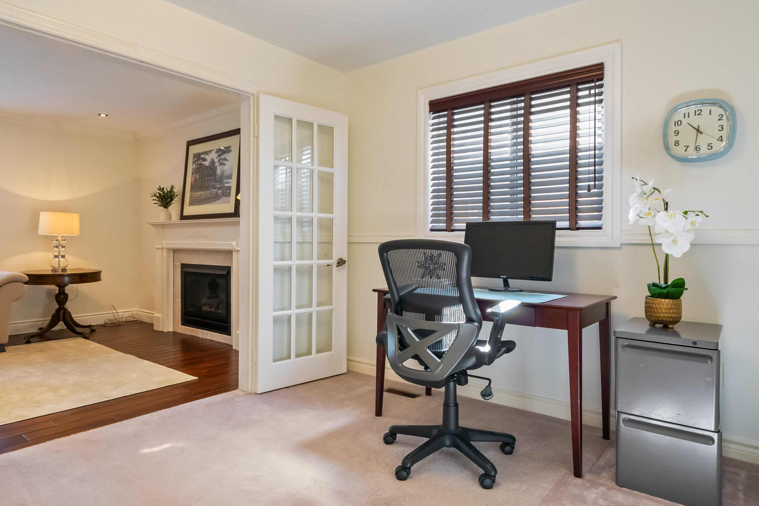 Cozy home office with a desk, chair, and decorative clock