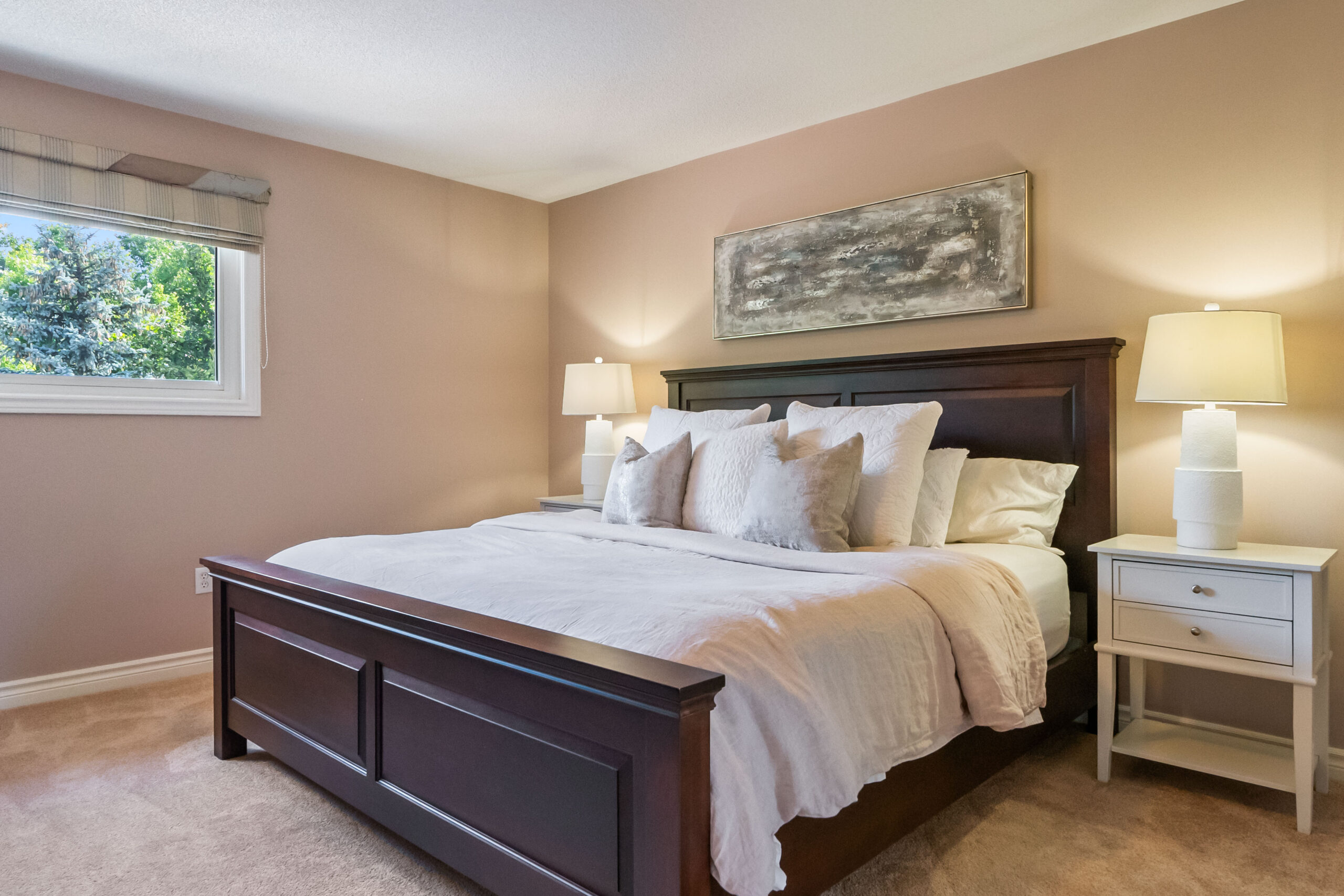Cozy bedroom with a wooden bed, soft bedding, and natural light from a window