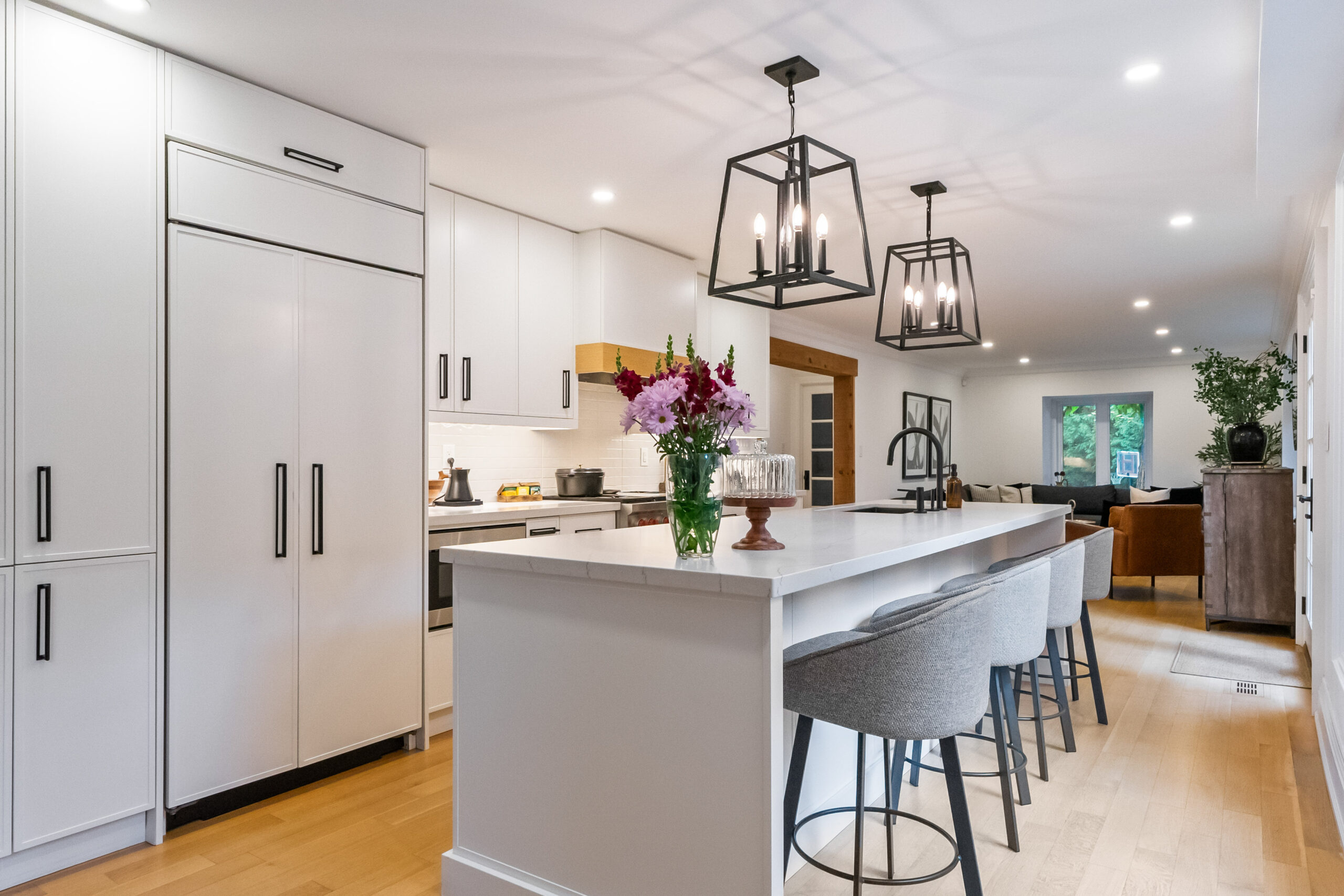 Modern kitchen with white cabinets, large island, and pendant lighting