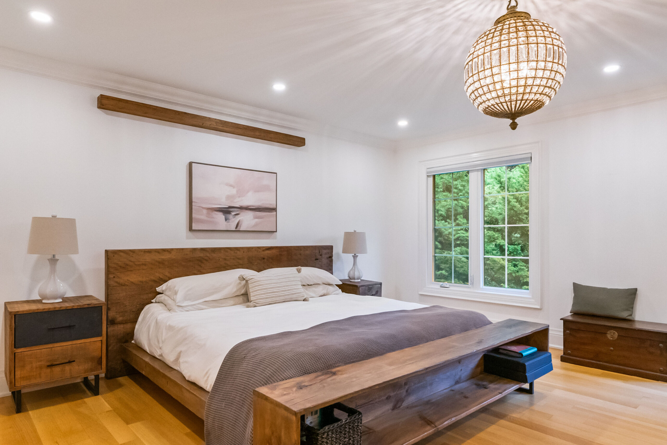 Modern bedroom with wooden bed, nightstands, and large windows