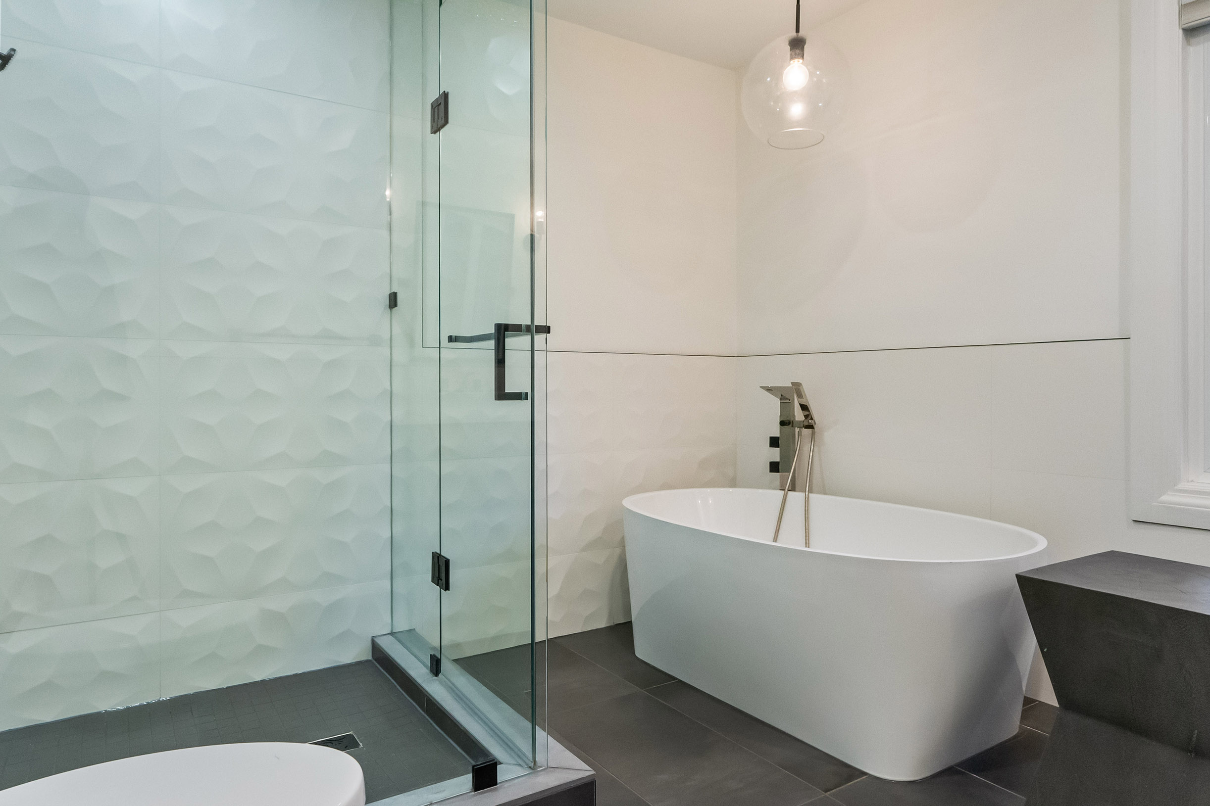 Modern bathroom featuring a glass shower and freestanding bathtub
