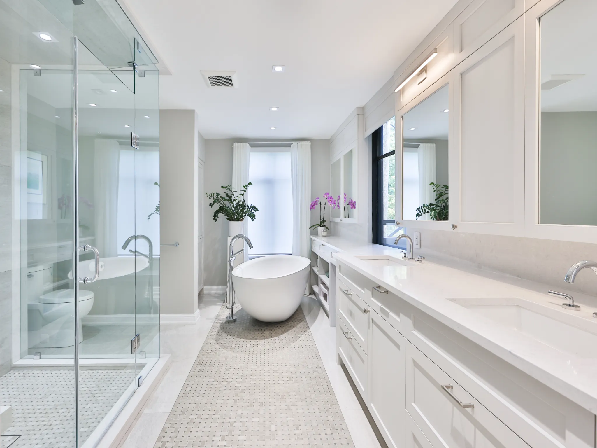 Modern bathroom featuring a freestanding tub, glass shower, and natural light.