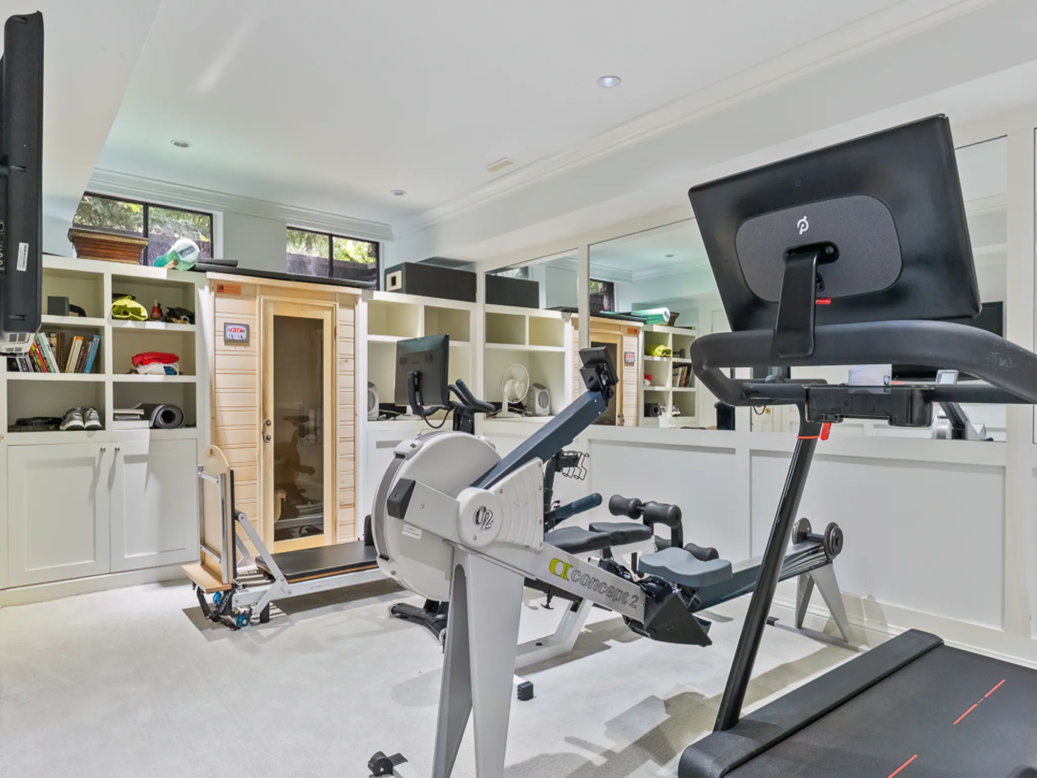 Home gym featuring exercise equipment and a sauna cabin