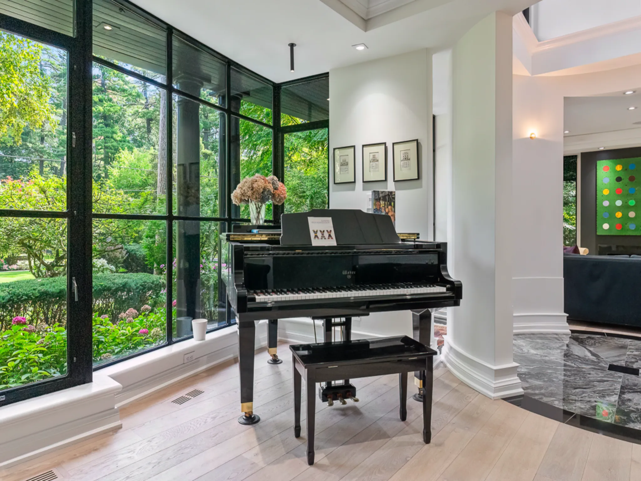 Grand piano in a bright room with large windows and garden view