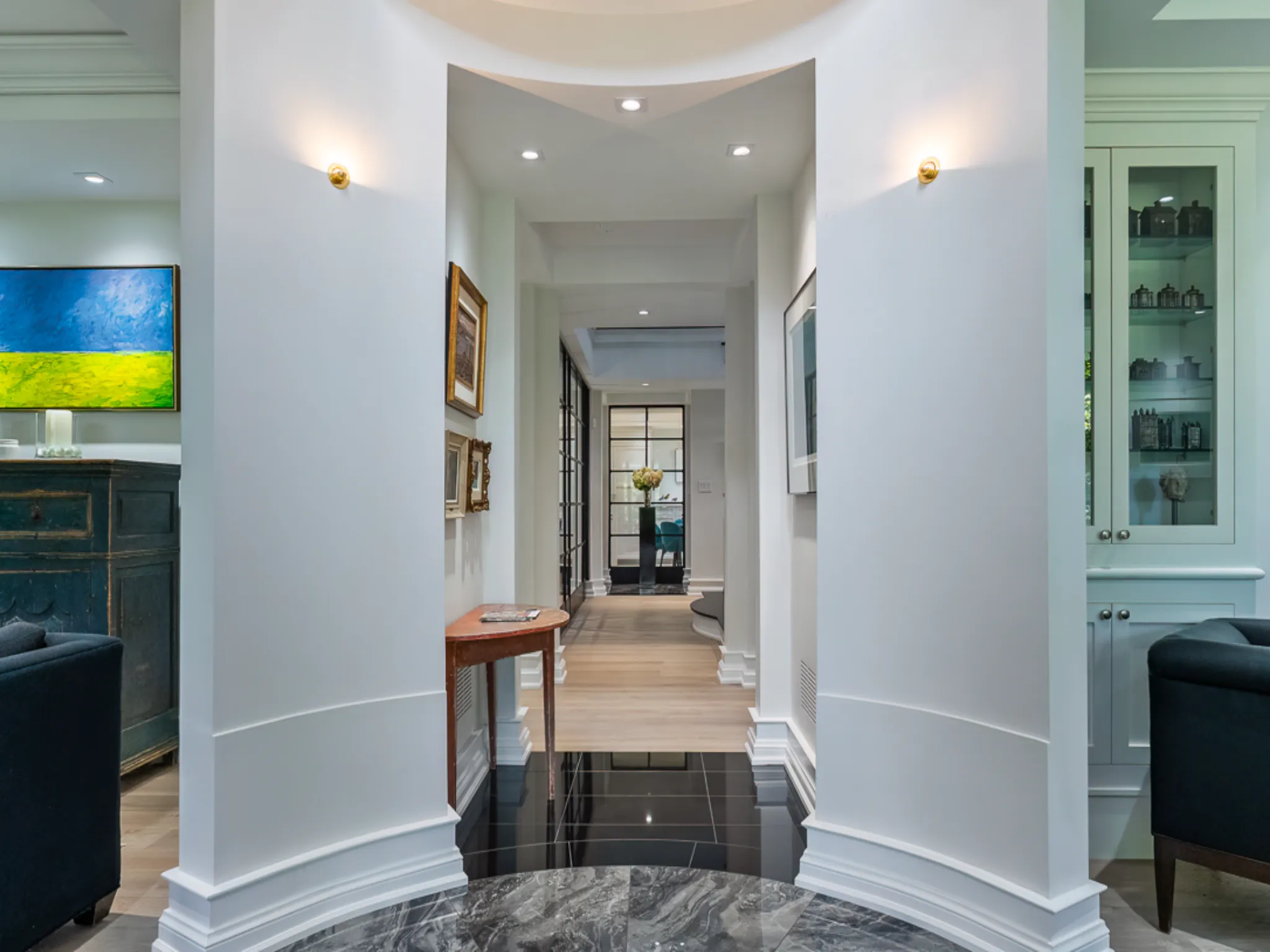 Elegant hallway with artwork, polished floors, and soft lighting