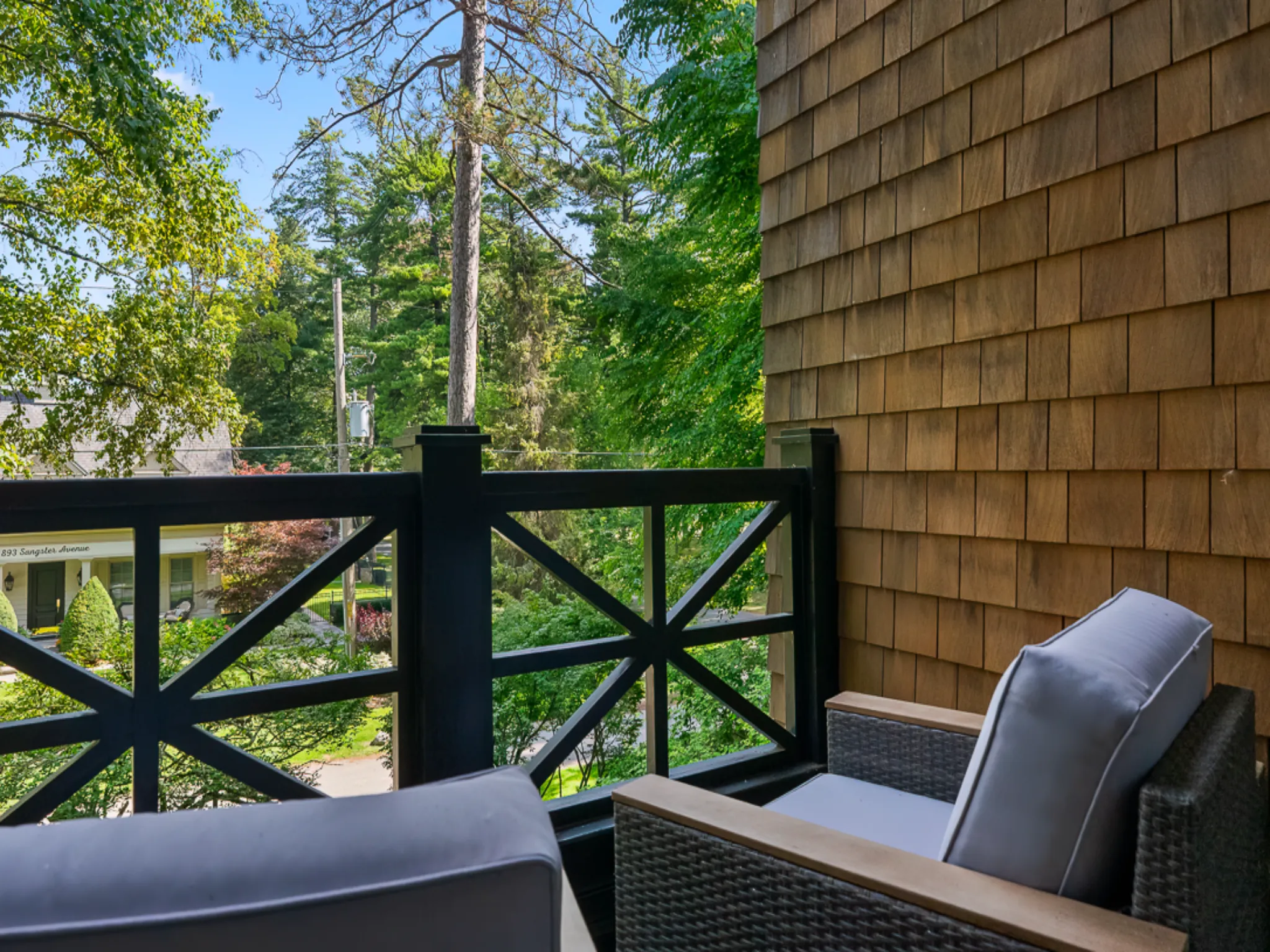 Cozy balcony view with two chairs and lush greenery in the background