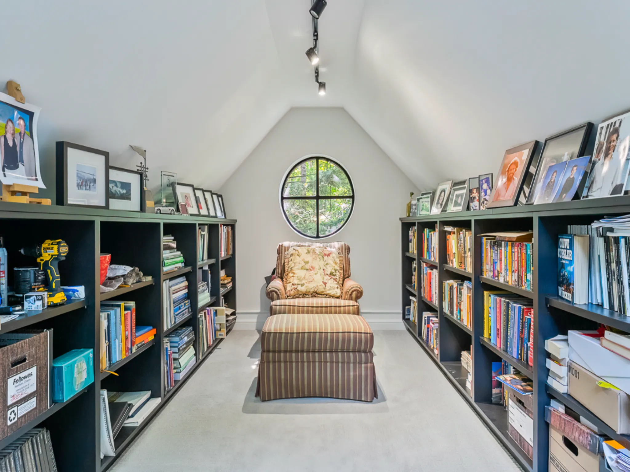 Cozy attic library with bookshelves and a round window