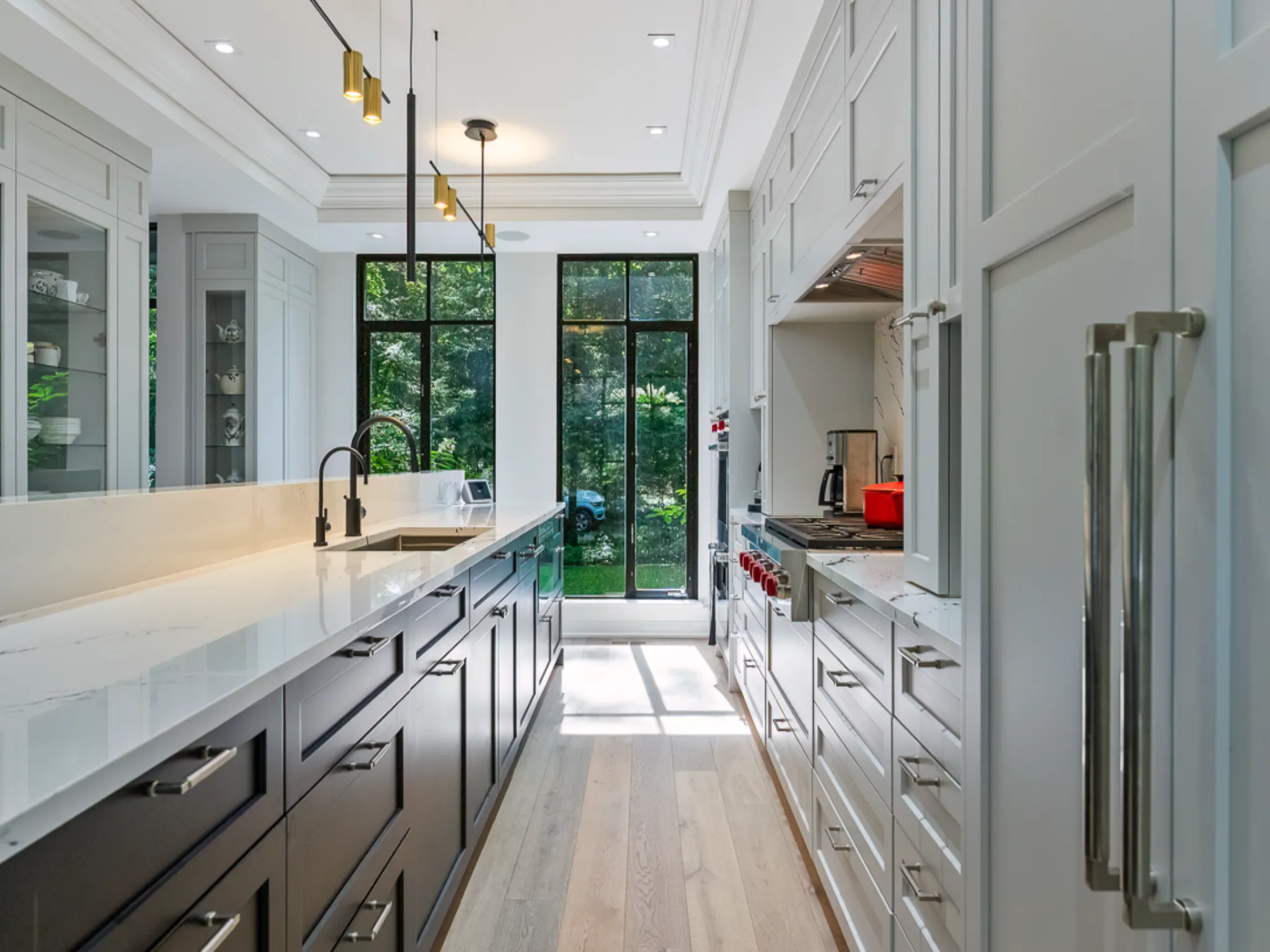 Modern kitchen with white cabinets, marble countertops, and large windows.