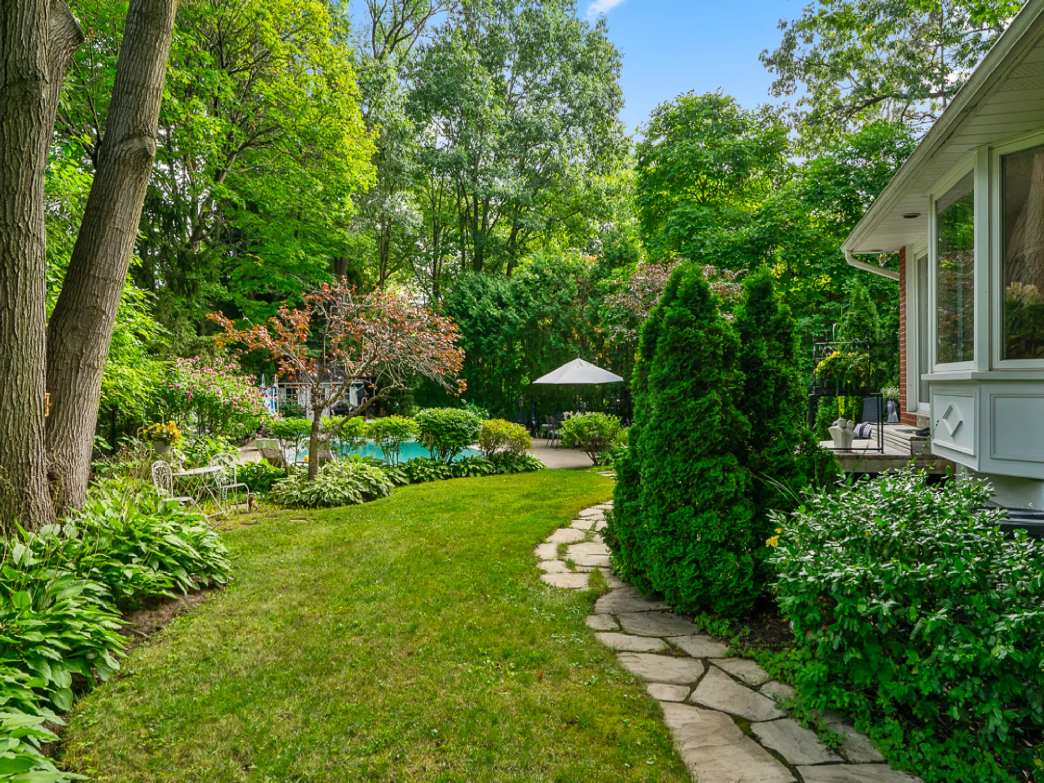 backyard with large trees and umbrella