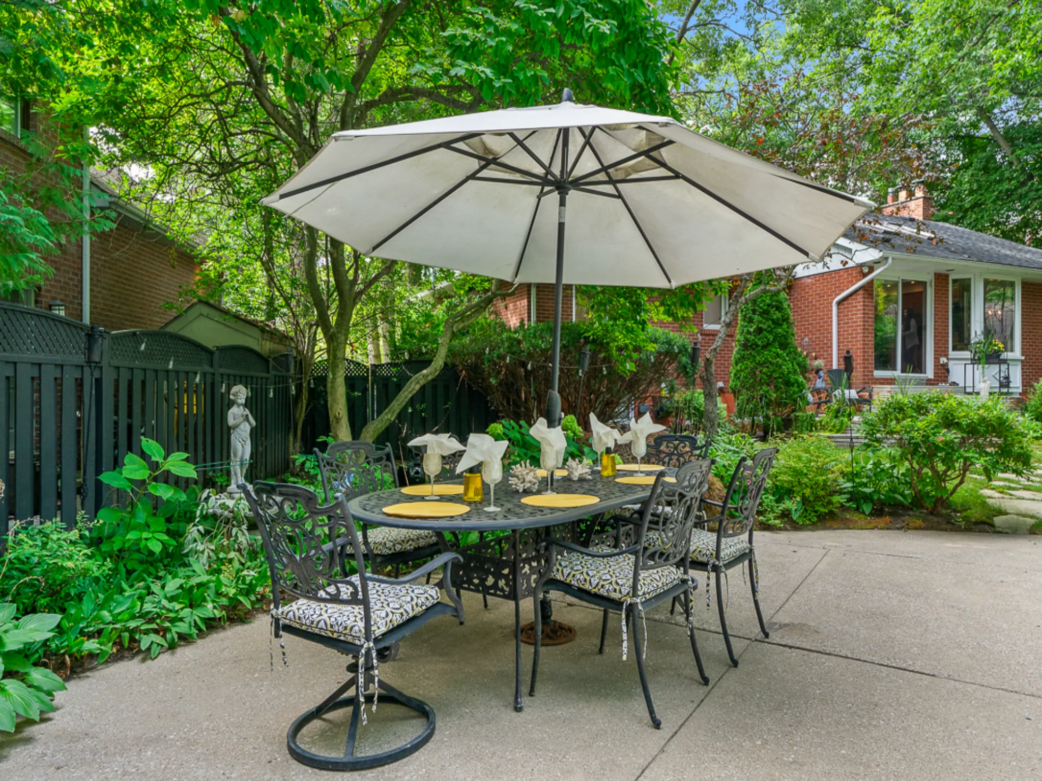 patio table with white umbrella in beautifully landscaped yard