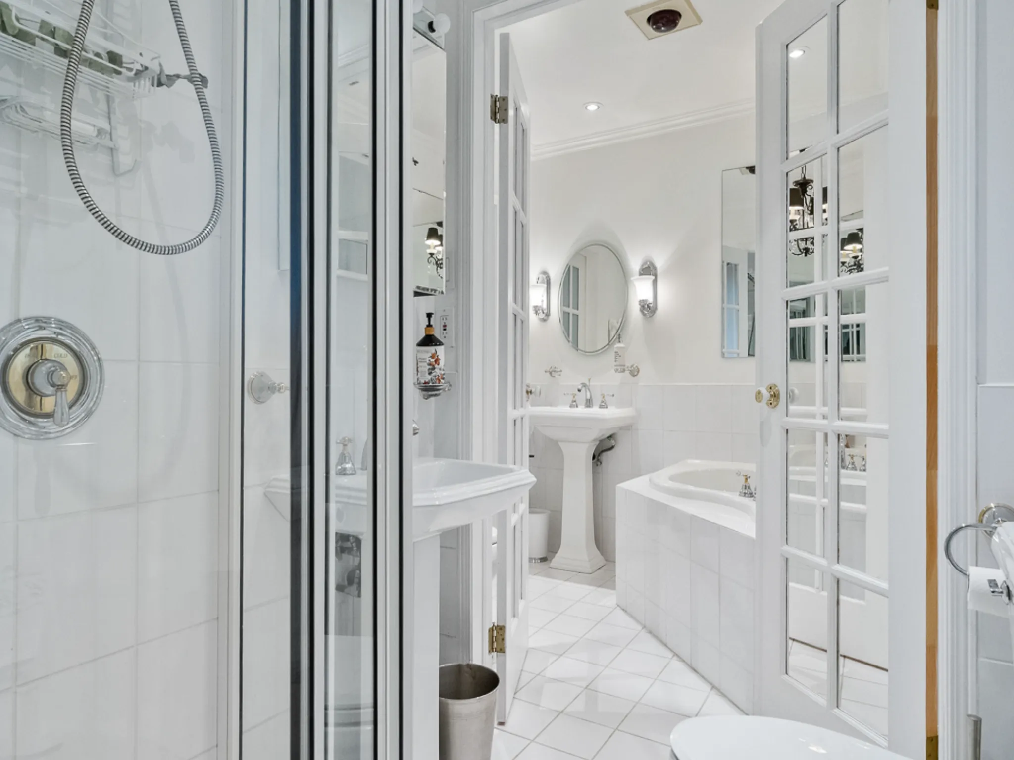 bathroom with shower and pedestal sinks