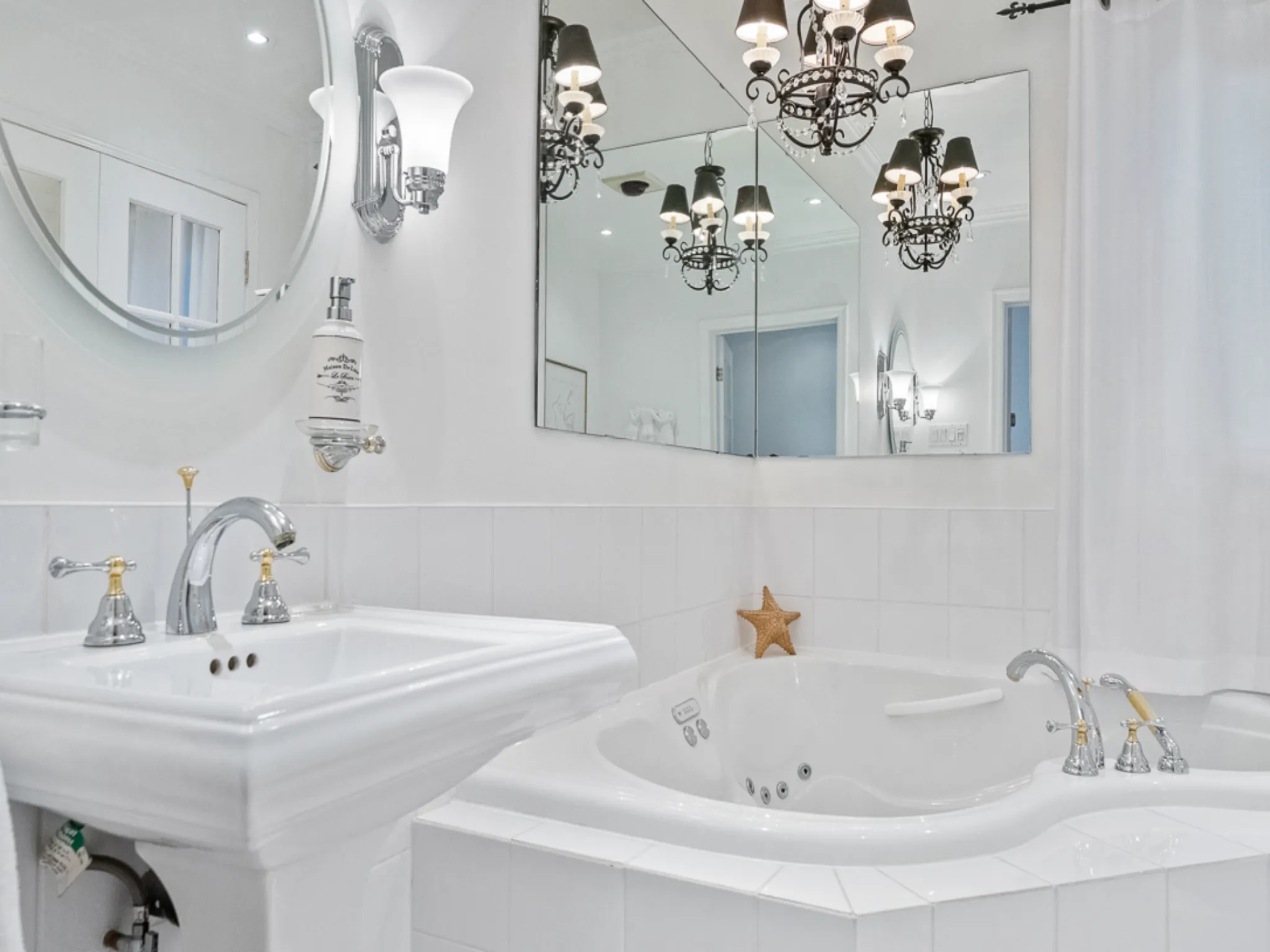 bathroom with soaker tub and chandelier