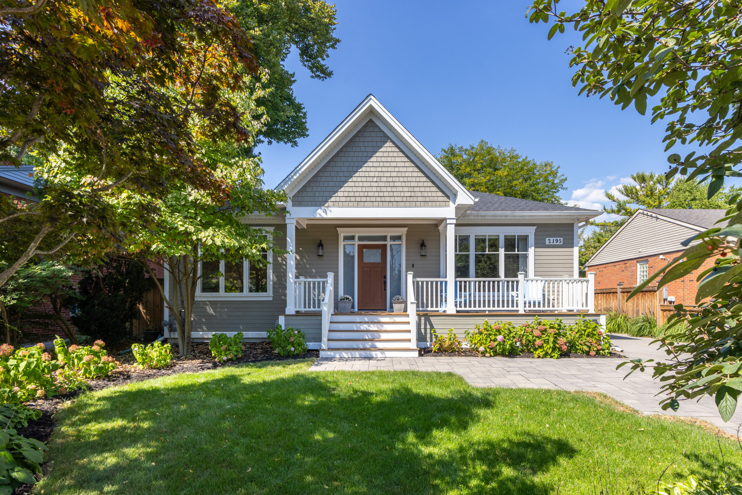 Charming gray house with a front porch and landscaped yard