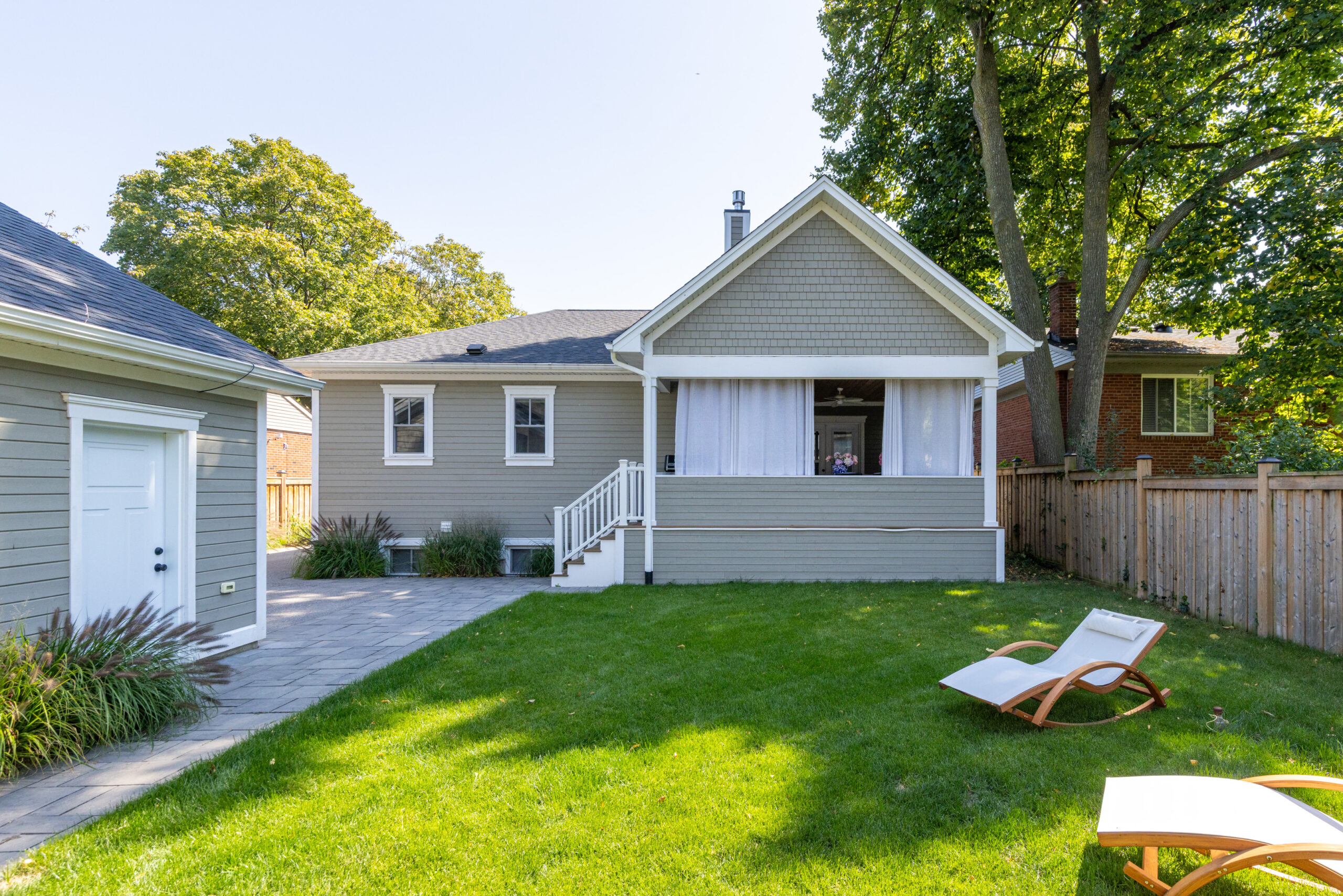 Backyard view of a house with a patio and lounge chair