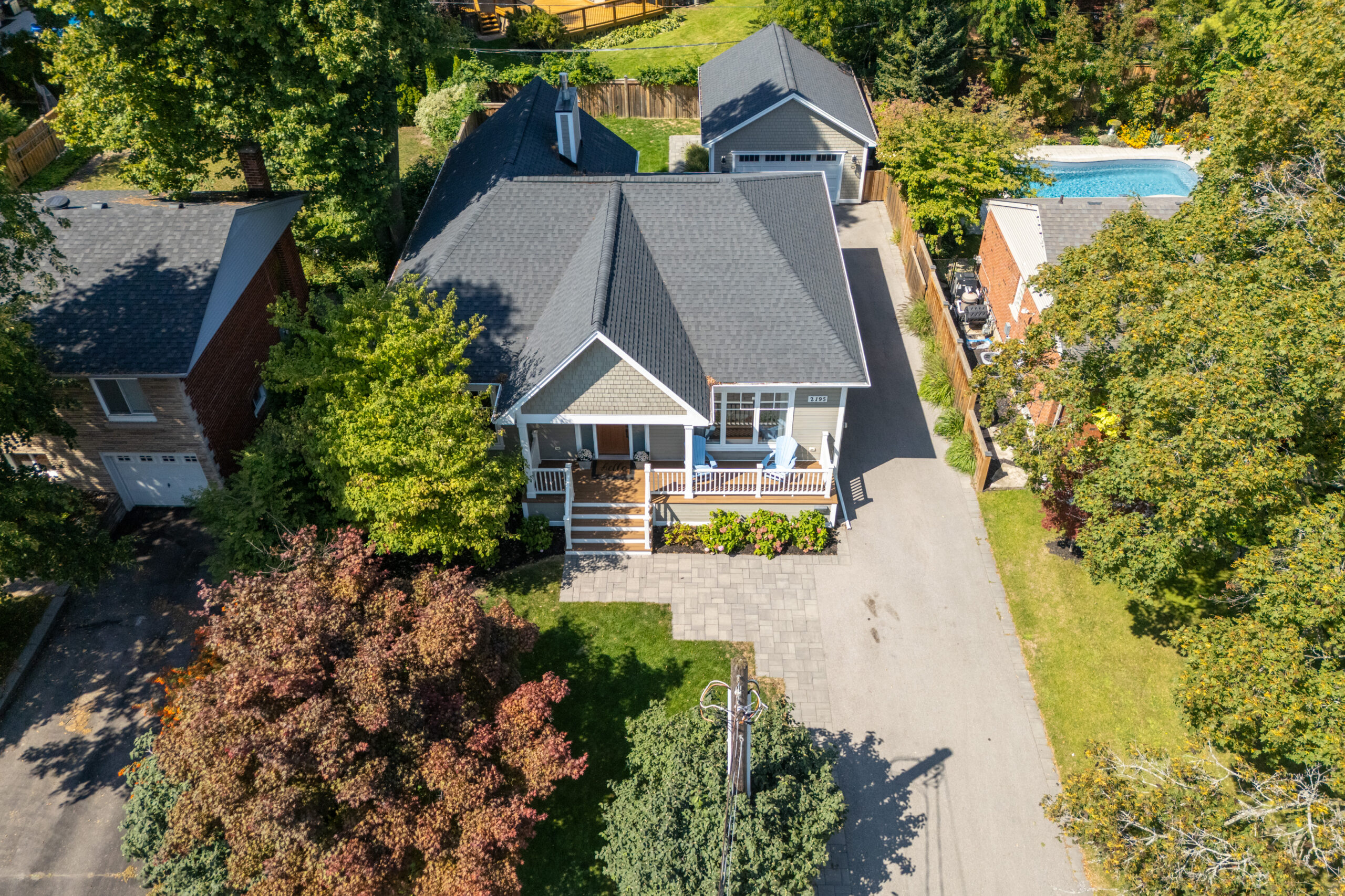 Aerial view of a house with a gray roof and landscaped yard