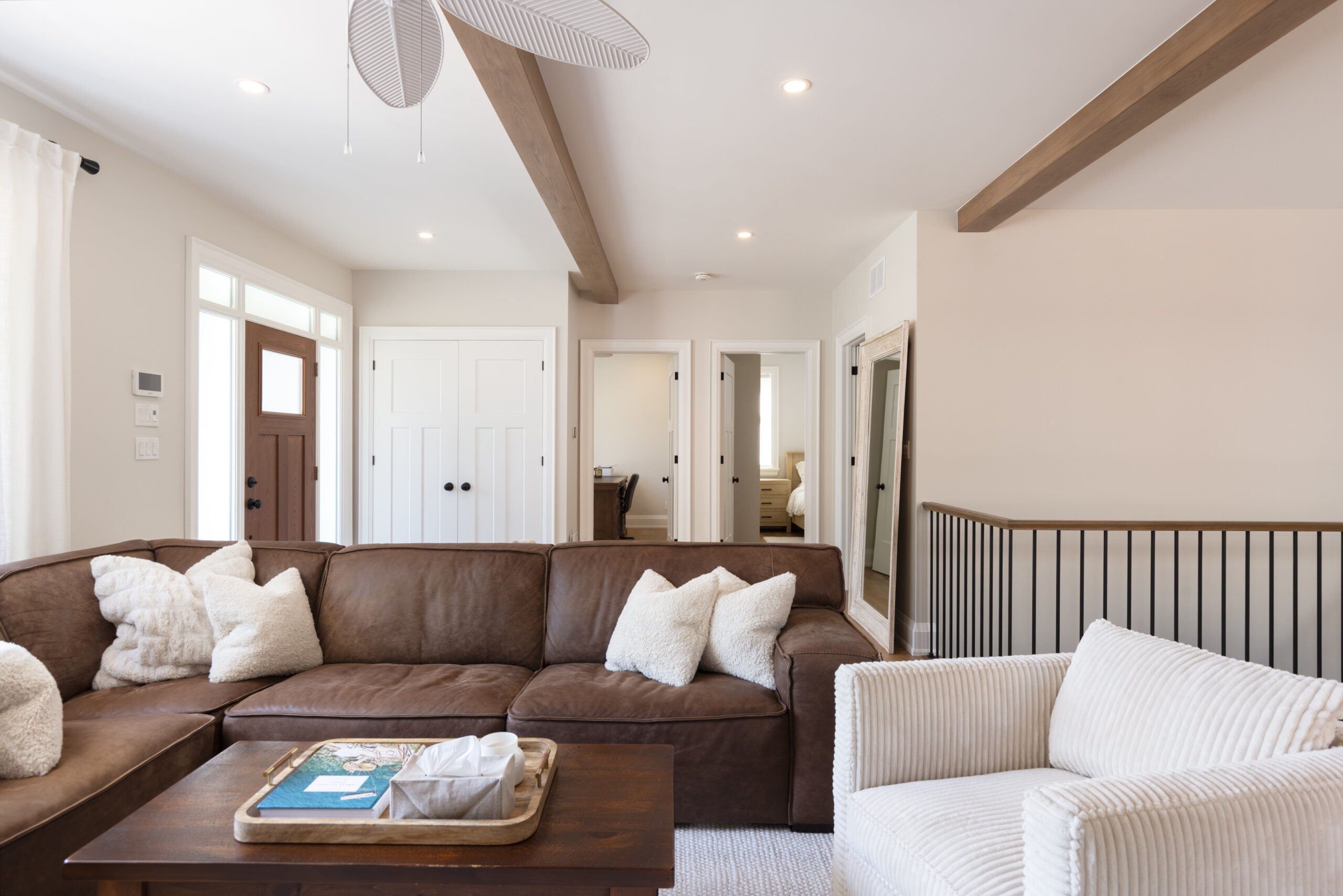 Cozy living room with brown sectional sofa and white armchair